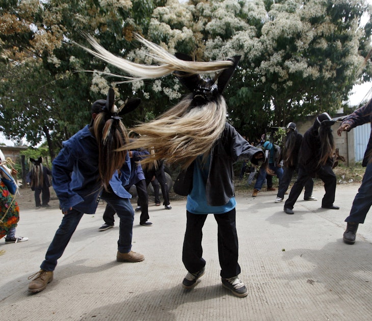 Three men in masks with long beards swing the hair around