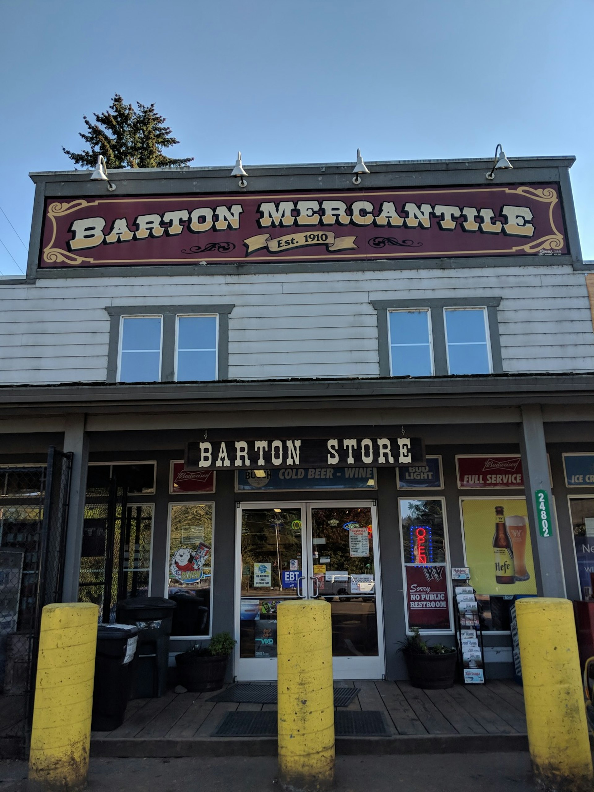 A maroon and off-white sign sits on top of one of Oregon's old-fashioned country stores