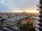 The sun sets over Bucharest's Old Town, with the iconic Palace of Parliament in the background © Monica Suma / Lonely Planet