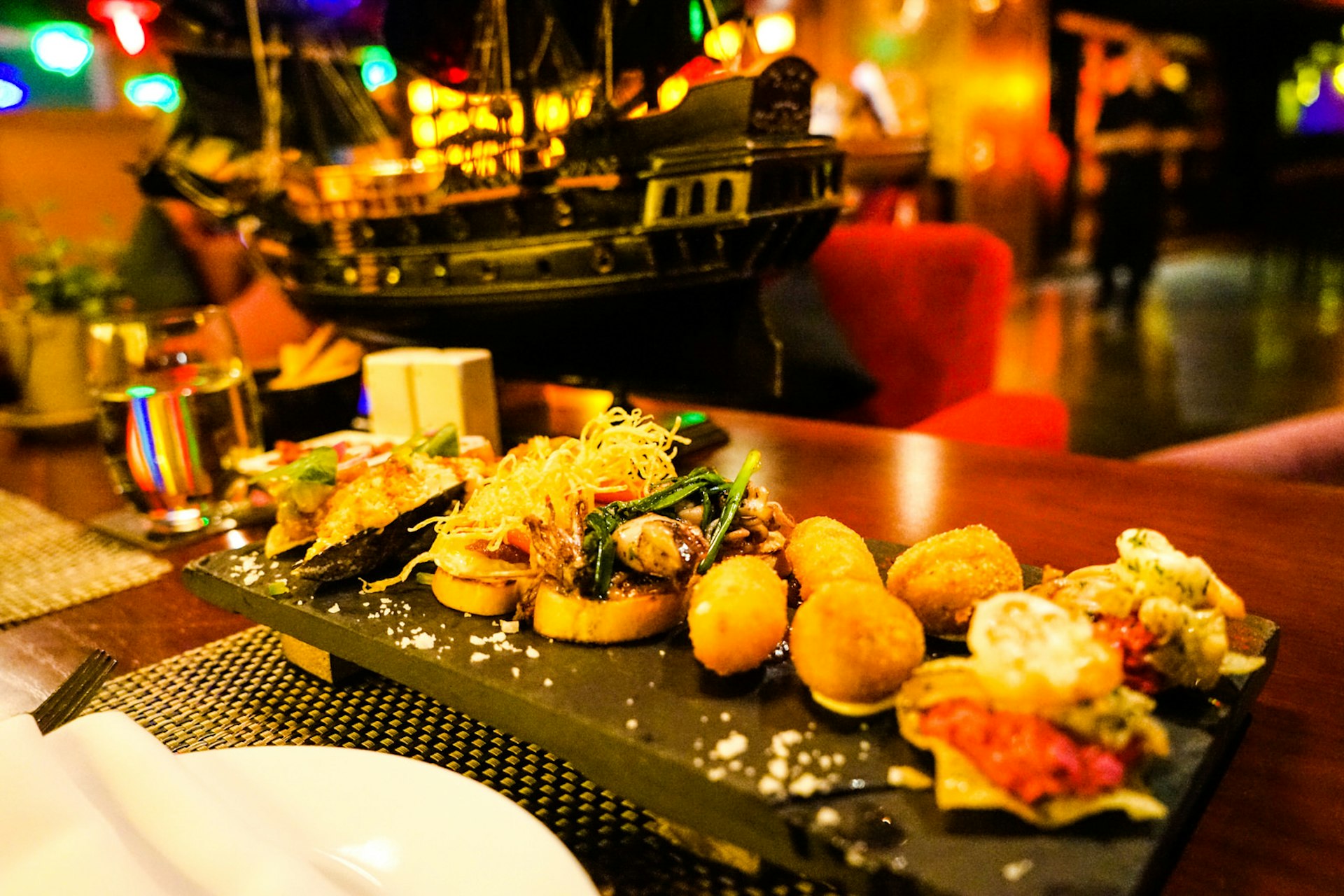 A selection of tapas served at Shri, in Ho Chi Minh City, on a slate. Including bruschetta, arancini balls and a number of other small bites. This rooftop bars has a nautical theme.