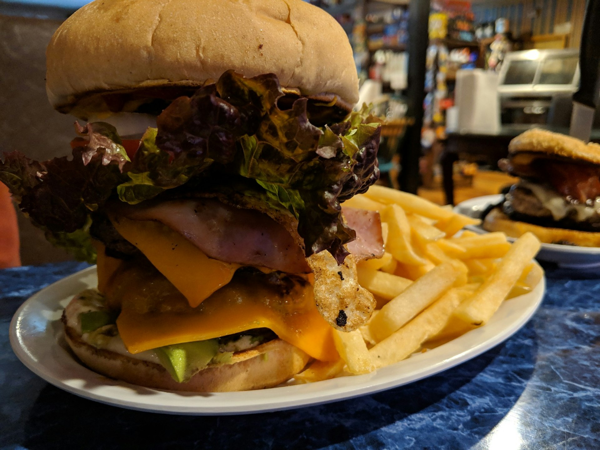 A massive burger is surrounded by fries