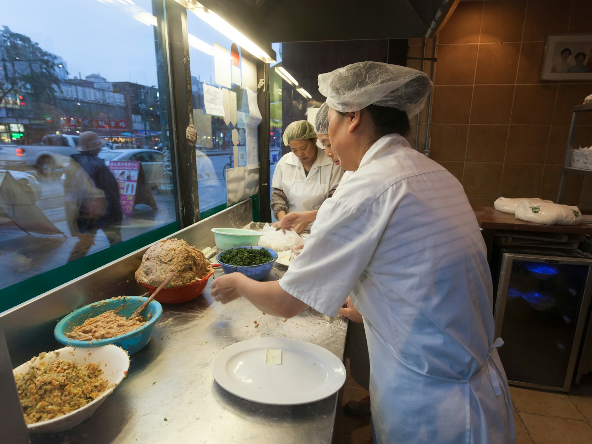 Women preparing dumplings at the front window of a restaurant in Toronto's Chinatown © Philip Lange / Shutterstock