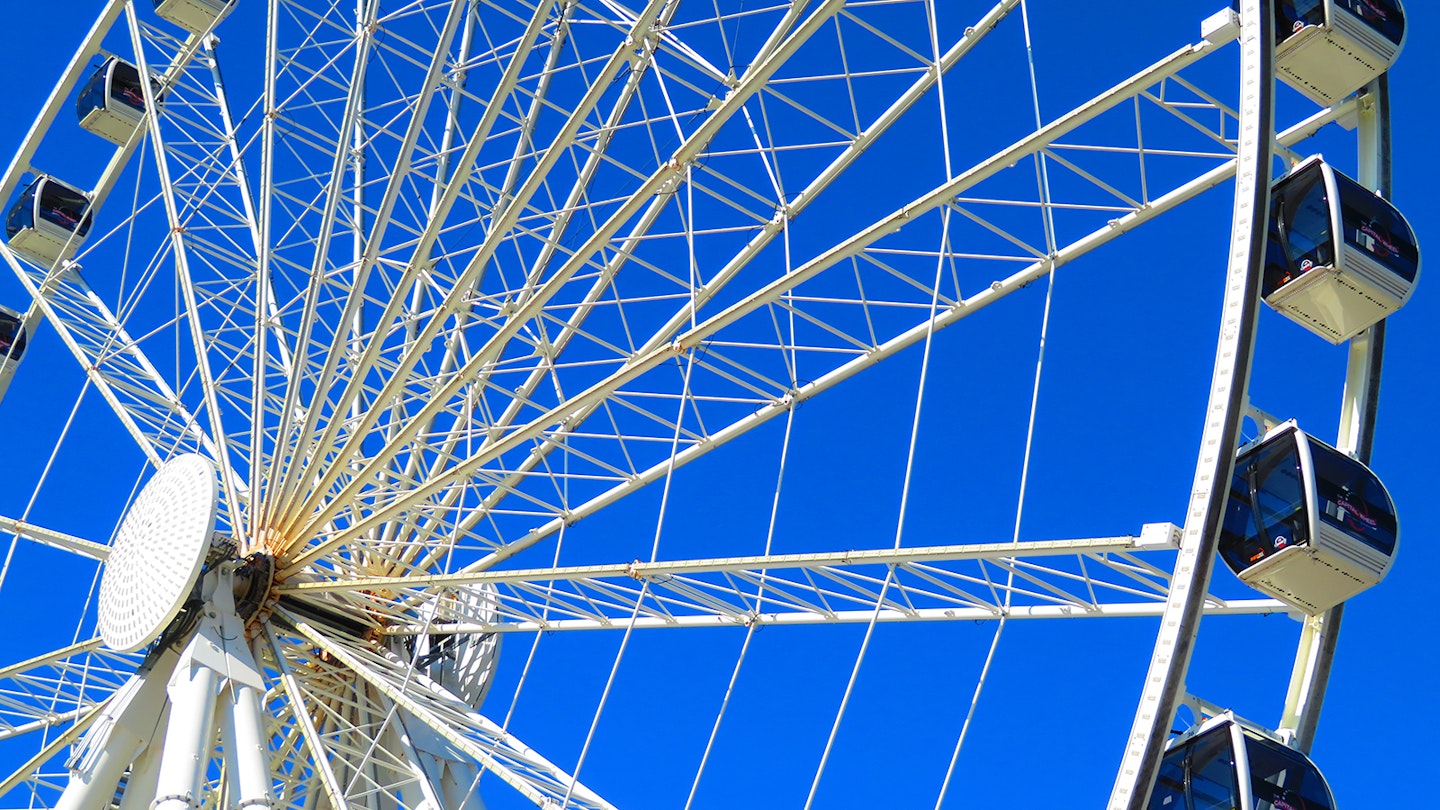 Close-up of white Ferris wheel, the Capital Wheel in National Harbor, against a bright blue sky