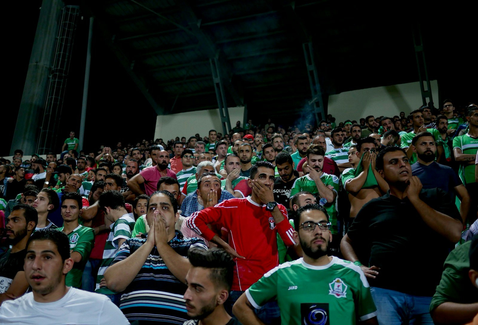 Wehdat fans react to the football match against Faisaly near Amman, Jordan