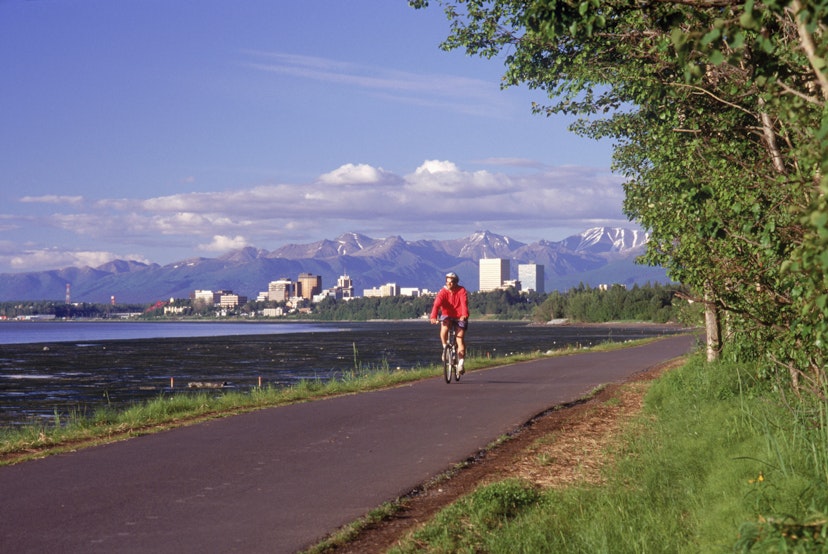 Features - Anchorage skyline w/ bike rider on coastal trail