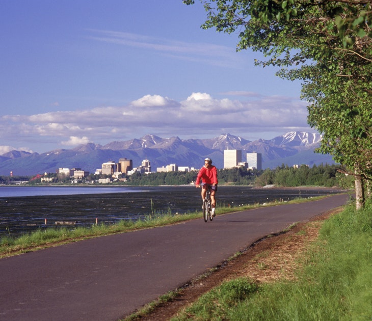 Features - Anchorage skyline w/ bike rider on coastal trail