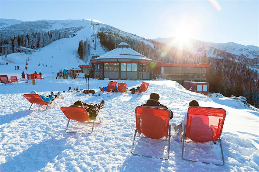 Jasna est une station de ski bon marché en Europe de l'Est Skieurs et snowboarders se reposer sur des chaises près d'un bar après ski sur les pentes de Jasna