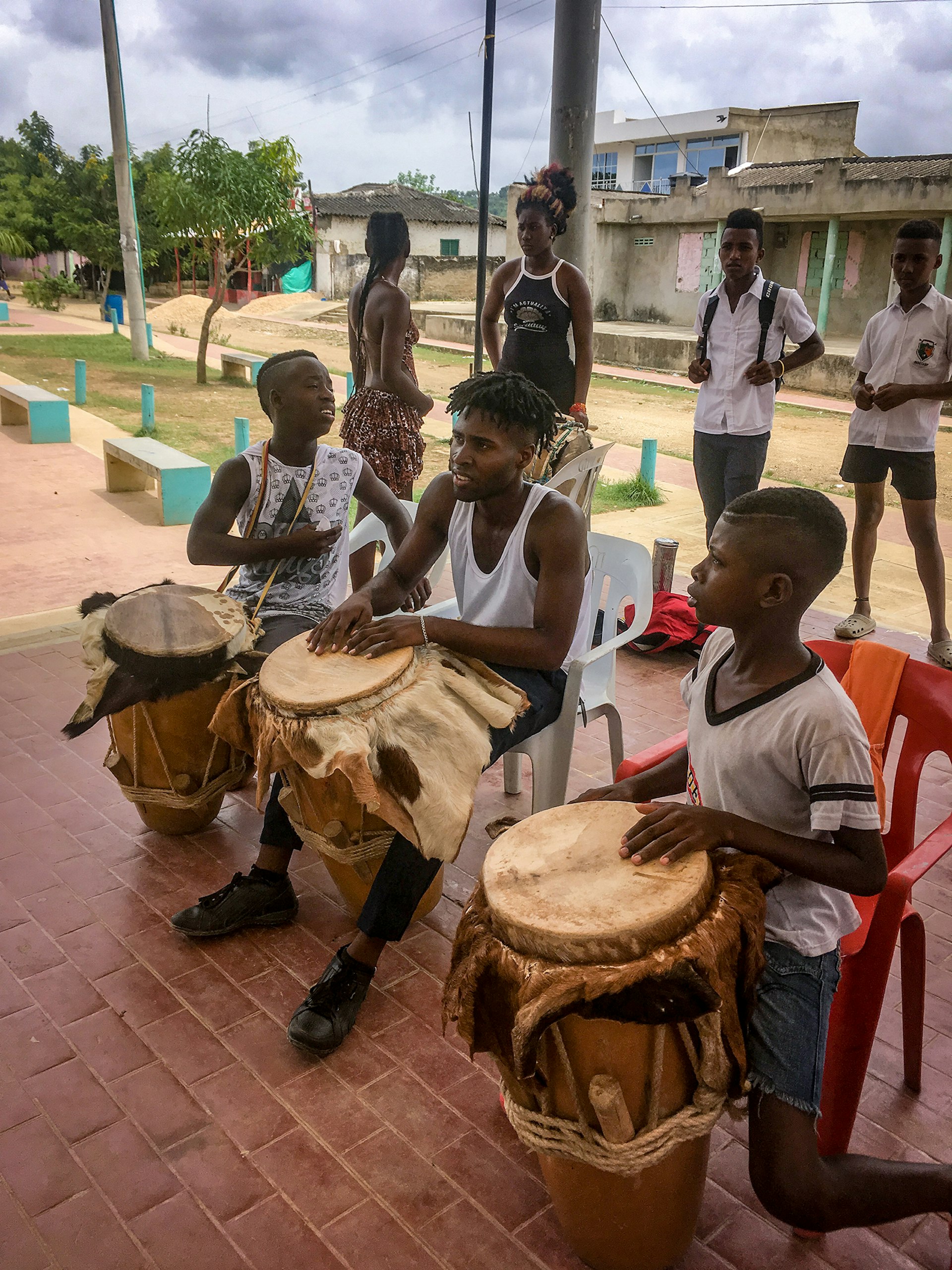 Three boys play traditional drums in Palenque, Colombia