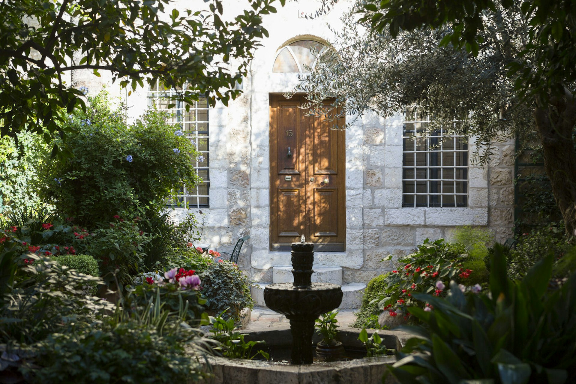 Lush courtyard with blossoming flowers at the American Colony Hotel, Jerusalem