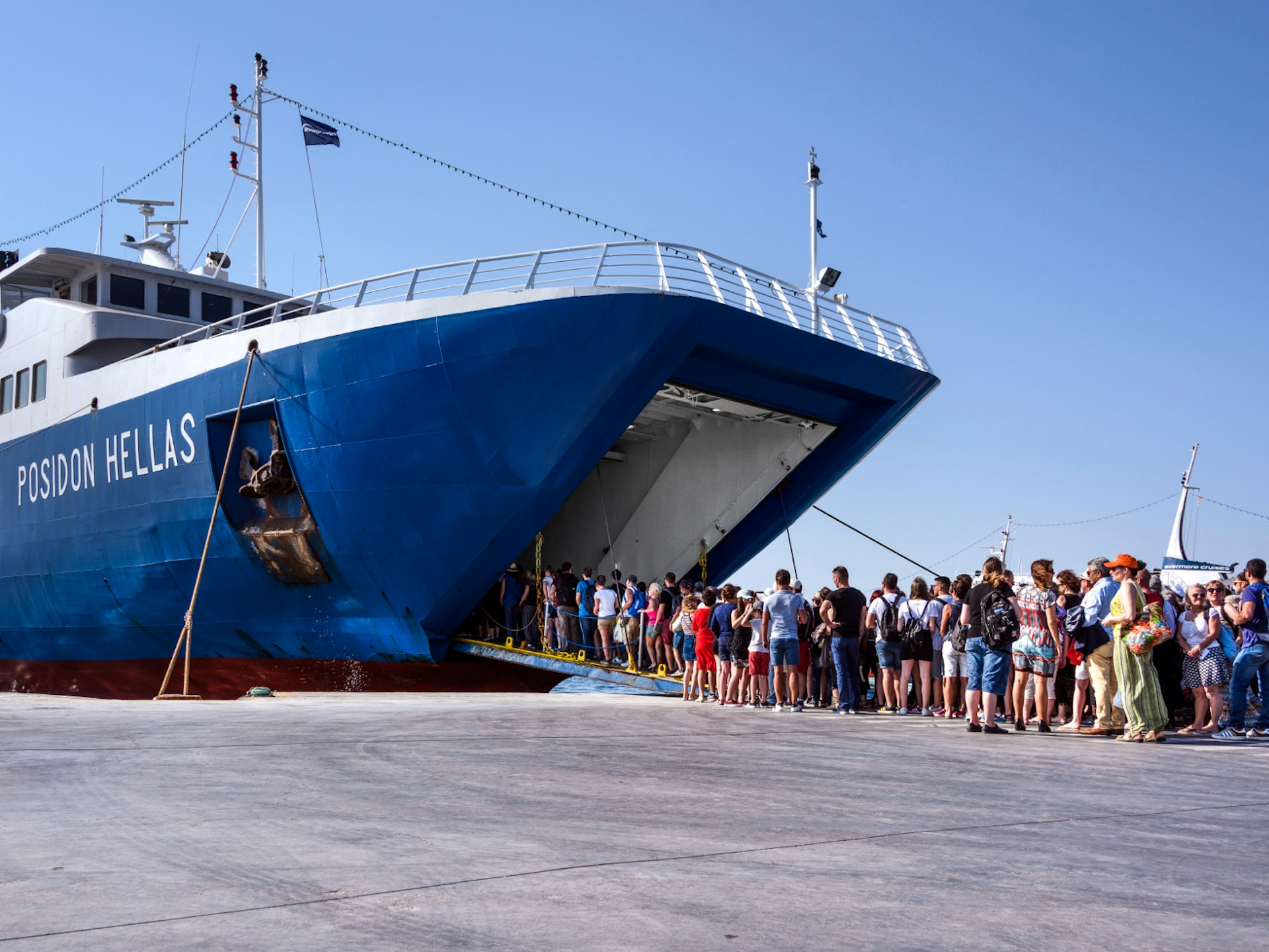 Travellers board a ferry in the port of Aegina island in the Saronic Gulf, Greece