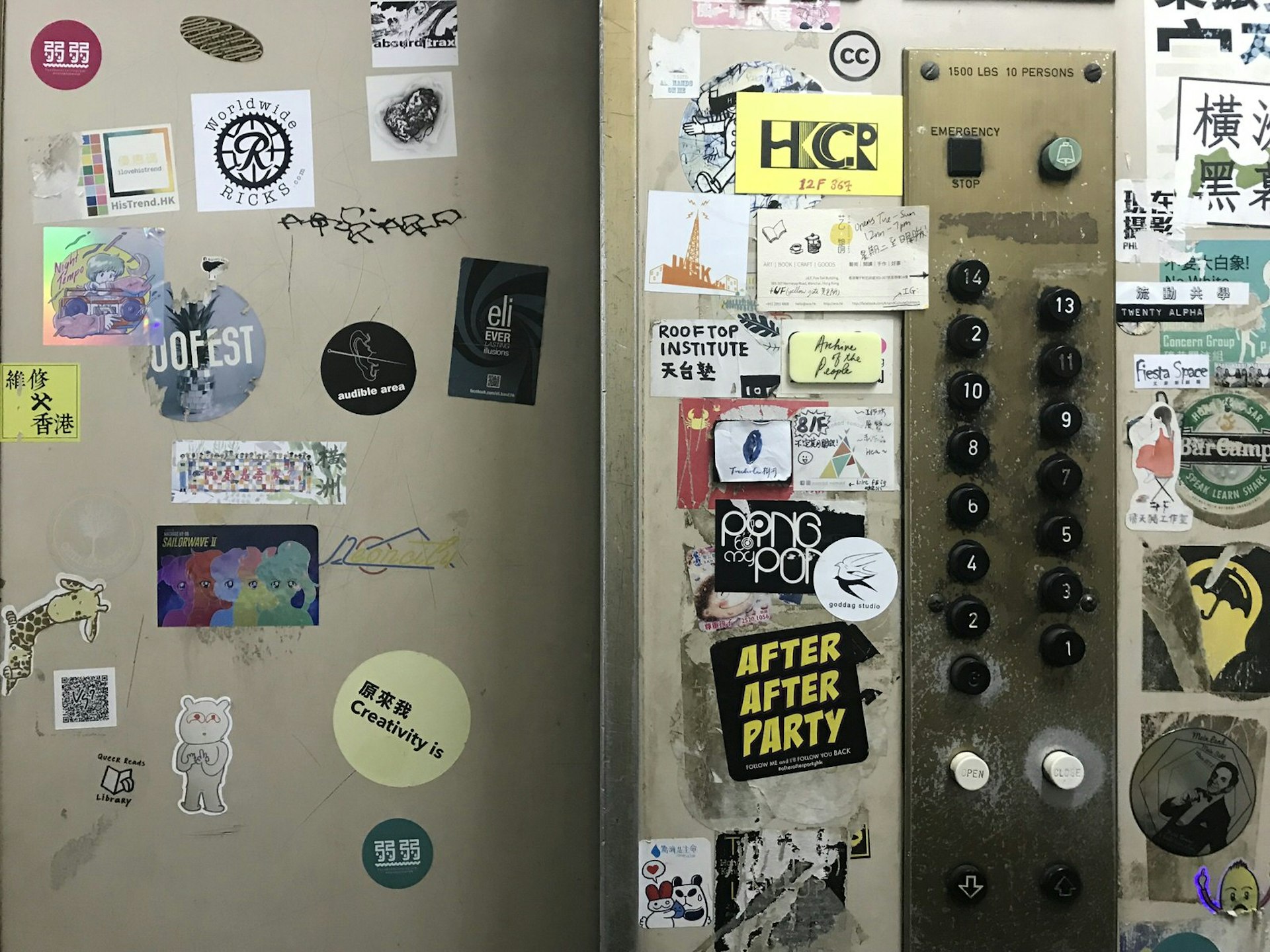 Old elevator doors and black buttons covered in stickers