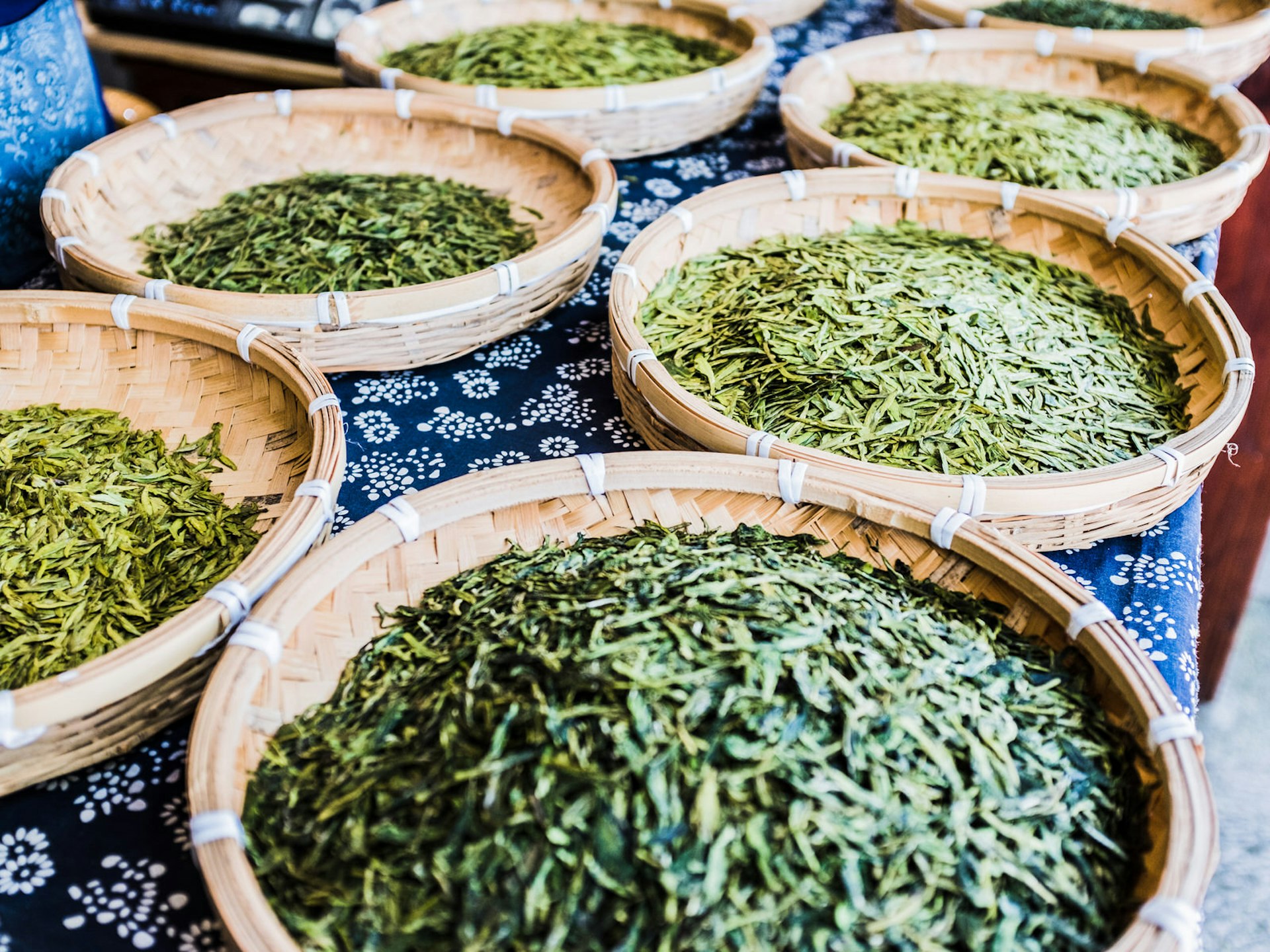 Several open baskets filled with drying tea leaves