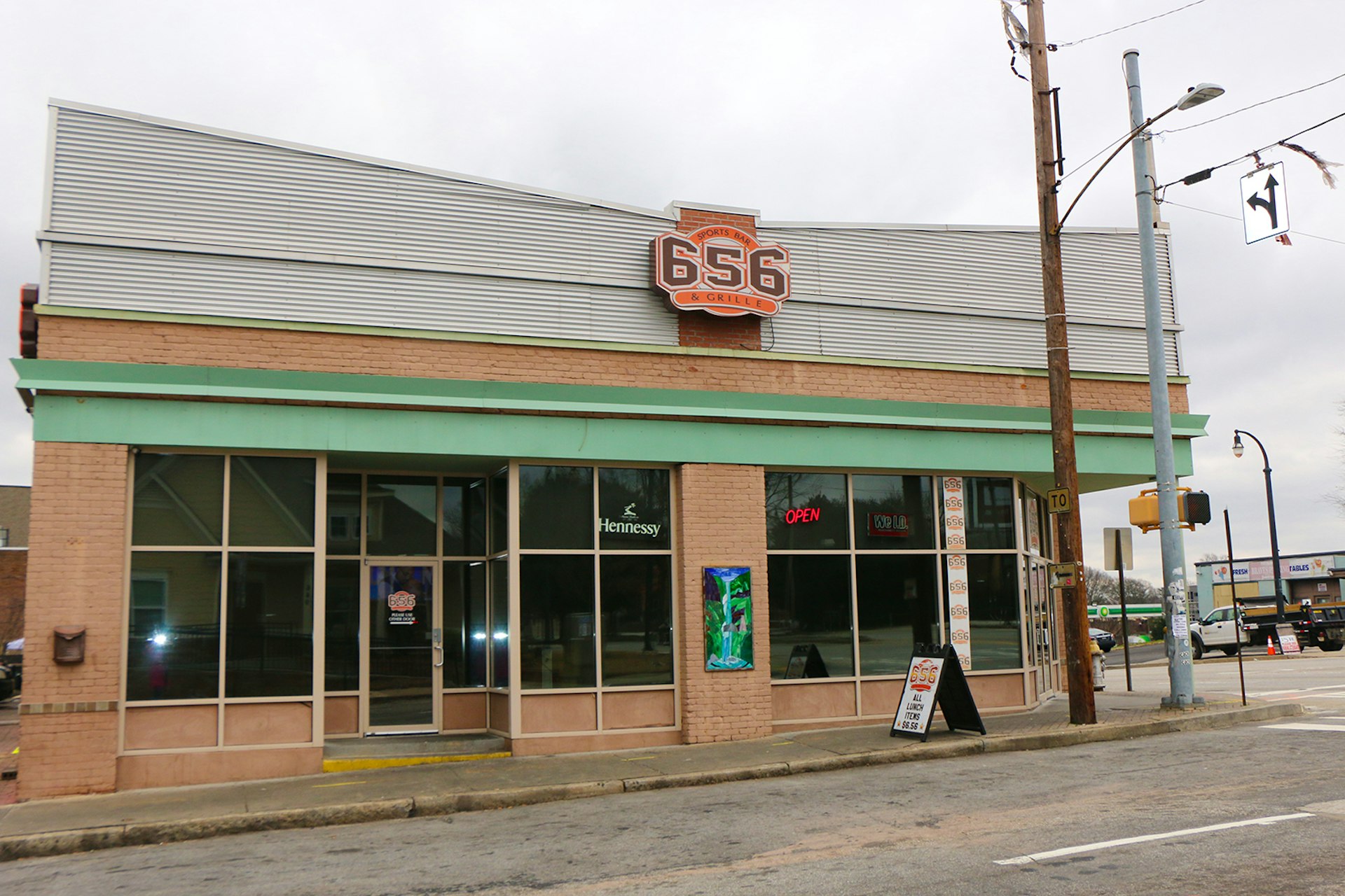 Facade of 656 sports bar, a one-story building in gold brick with an aluminum mid-century roof signage