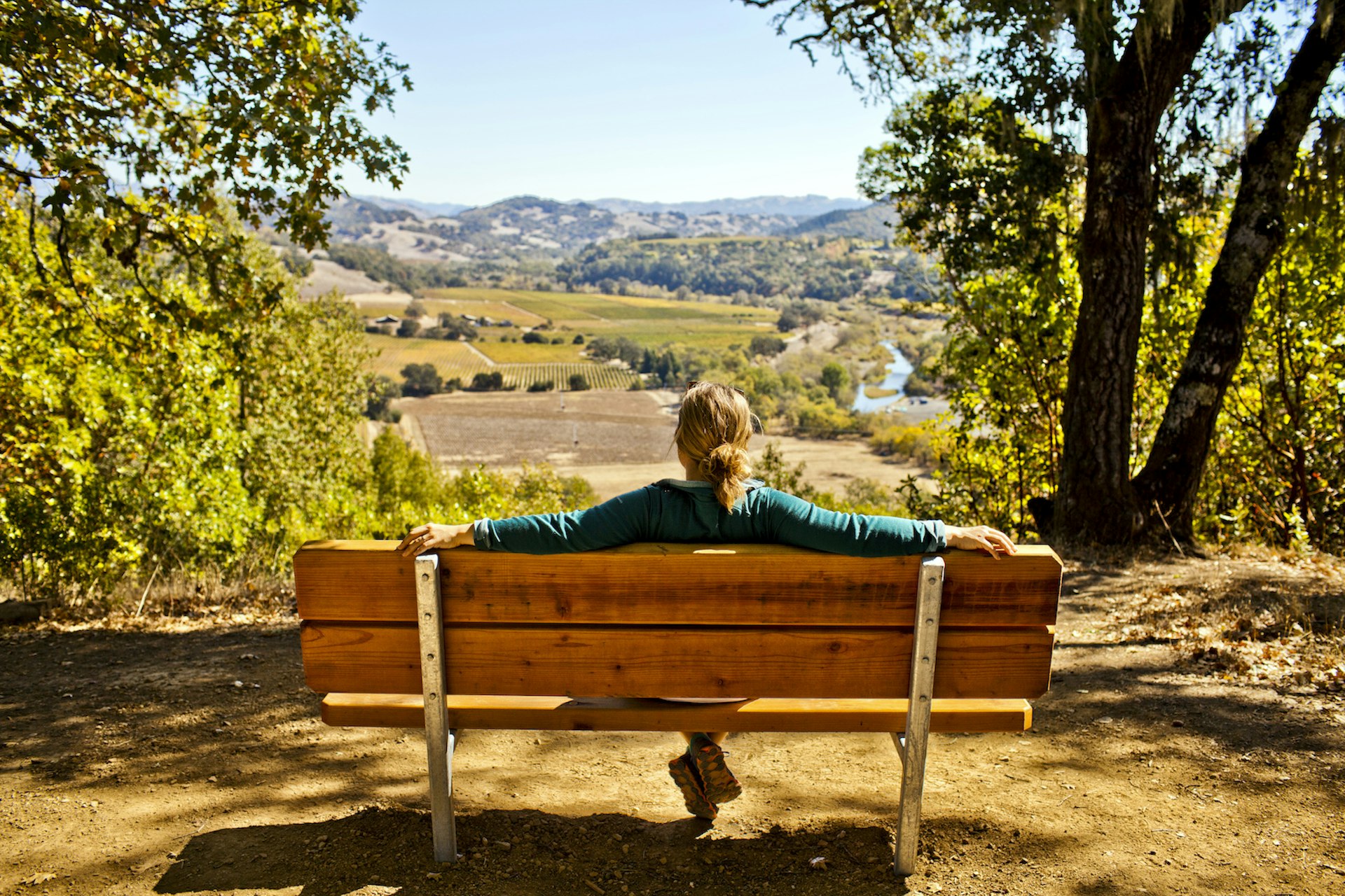 A woman sitting on a bench looking out over the countryside of Sonoma County, California