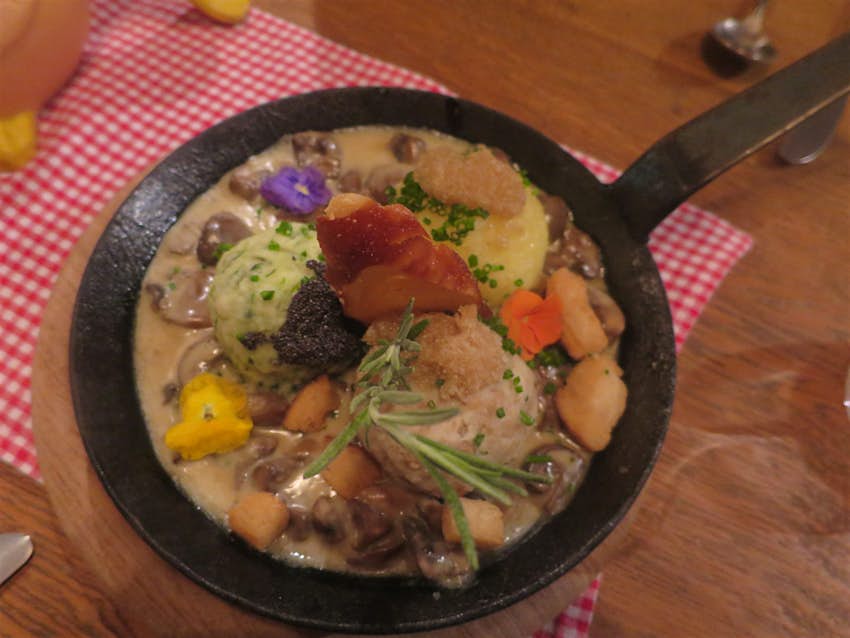 Traditional dish of dumplings -- both potato and bread versions -- at Ehrbar Weinstube, Frickenhausen. The dish is served in a small, iron fying pan and decorated with edible flowers and thyme