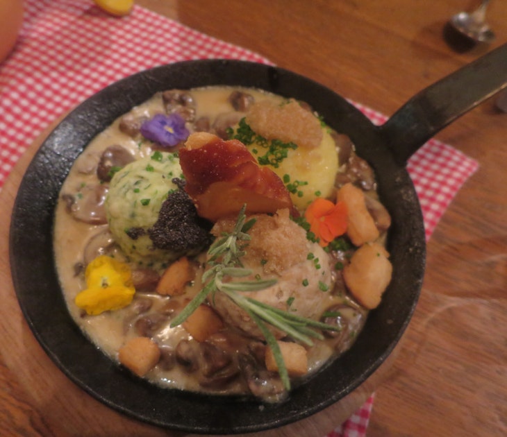 Traditional dish of dumplings -- both potato and bread versions -- at Ehrbar Weinstube, Frickenhausen. The dish is served in a small, iron fying pan and decorated with edible flowers and thyme