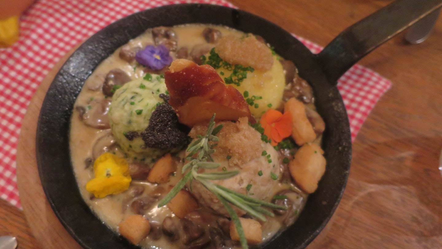 Traditional dish of dumplings -- both potato and bread versions -- at Ehrbar Weinstube, Frickenhausen. The dish is served in a small, iron fying pan and decorated with edible flowers and thyme