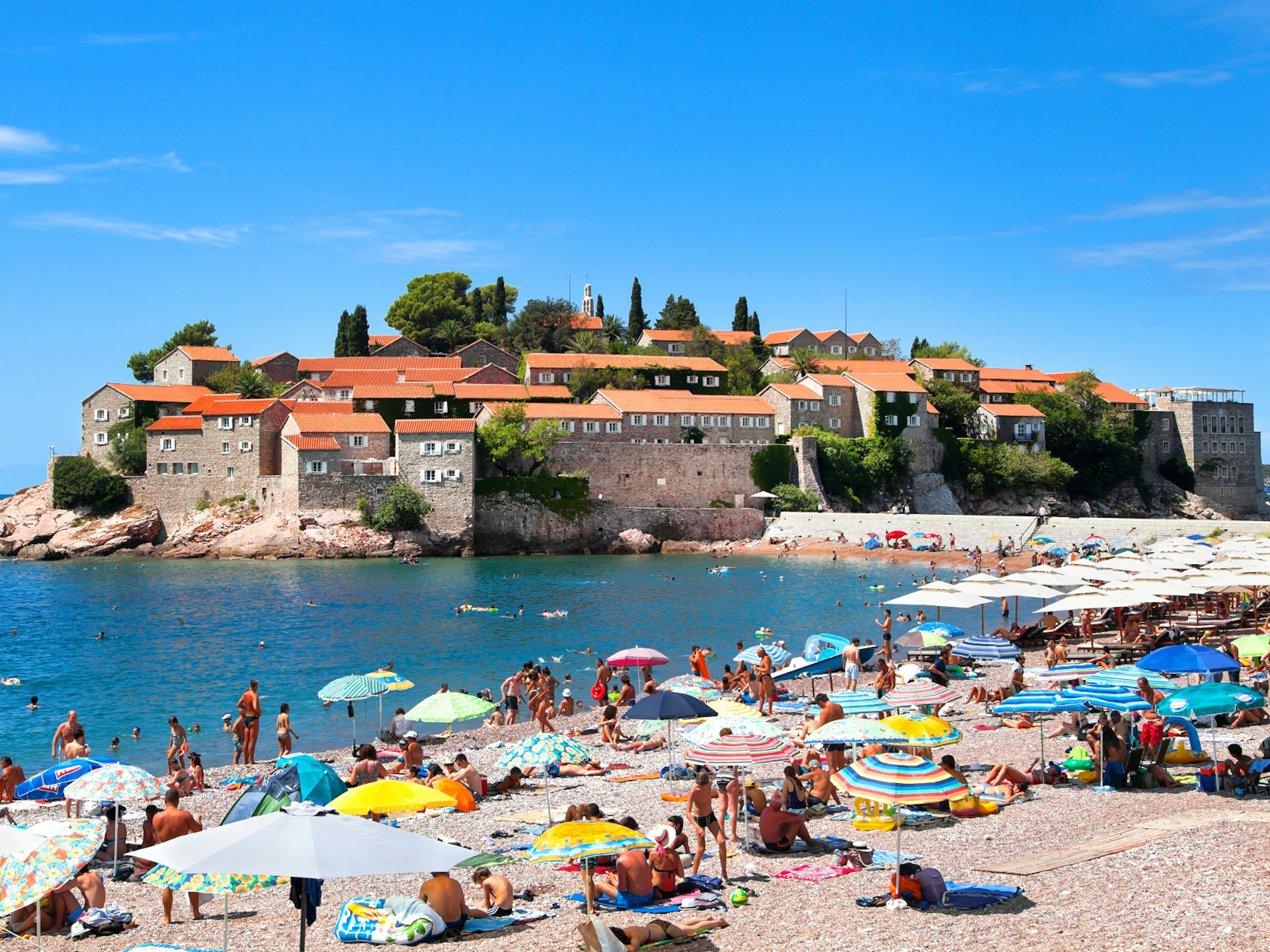Gorgeous views of Sveti Stefan from the pinkish sands at its southern end © photosmatic / Shutterstock