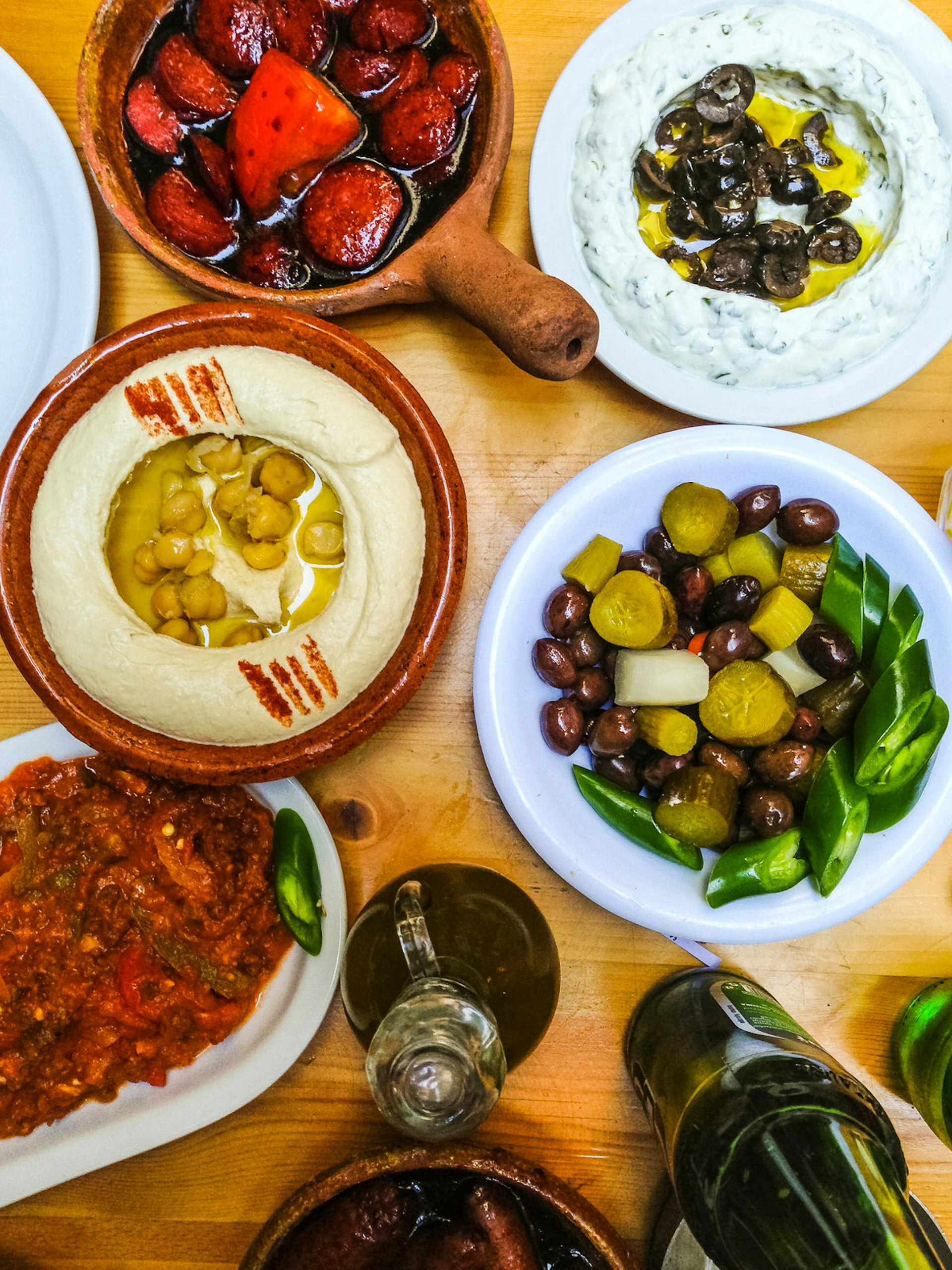 View of hummus and various appetisers served on a wooden table