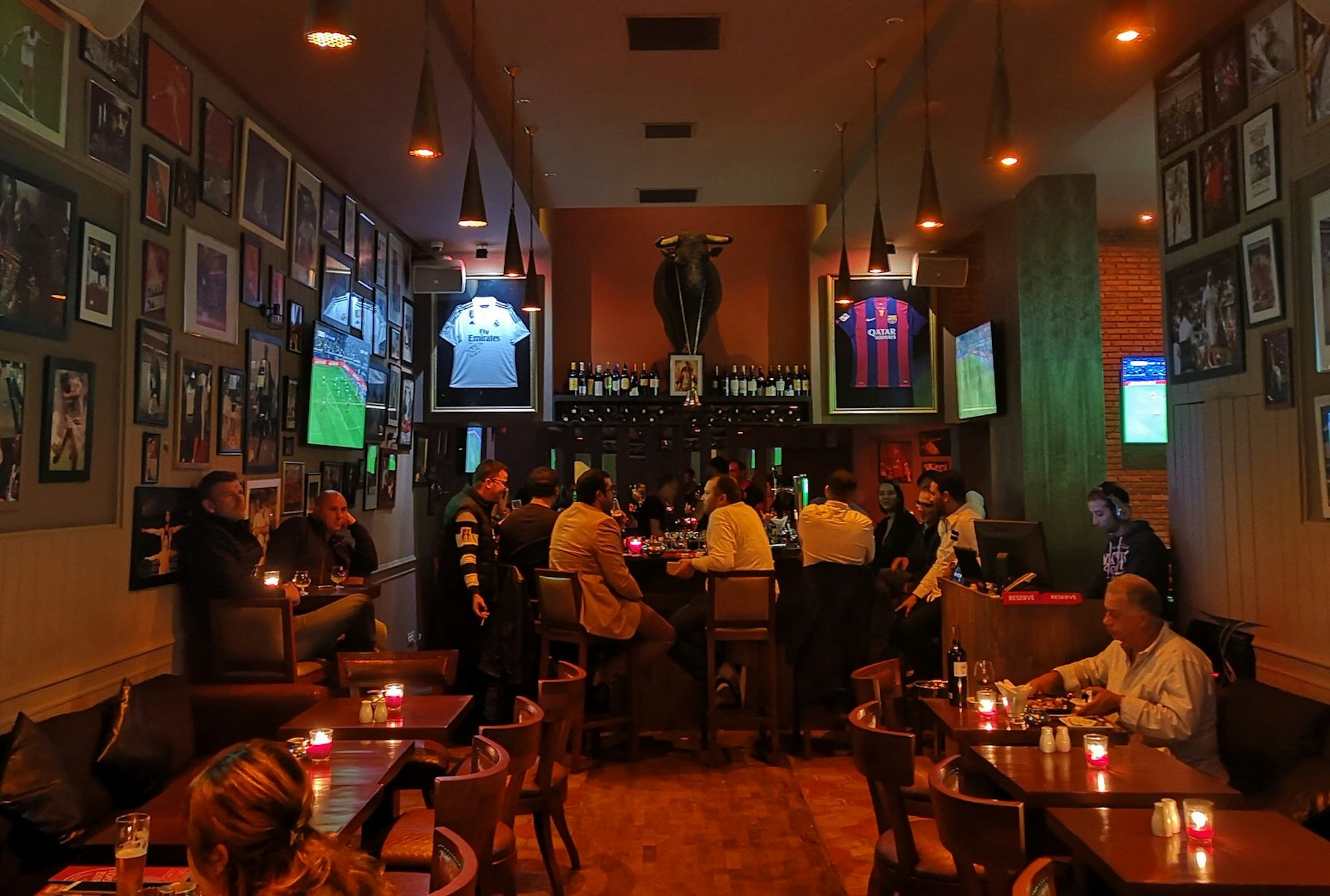 Customers gathered around a bar watching football at L'Auberge Espagnole, Marrakesh, Morocco