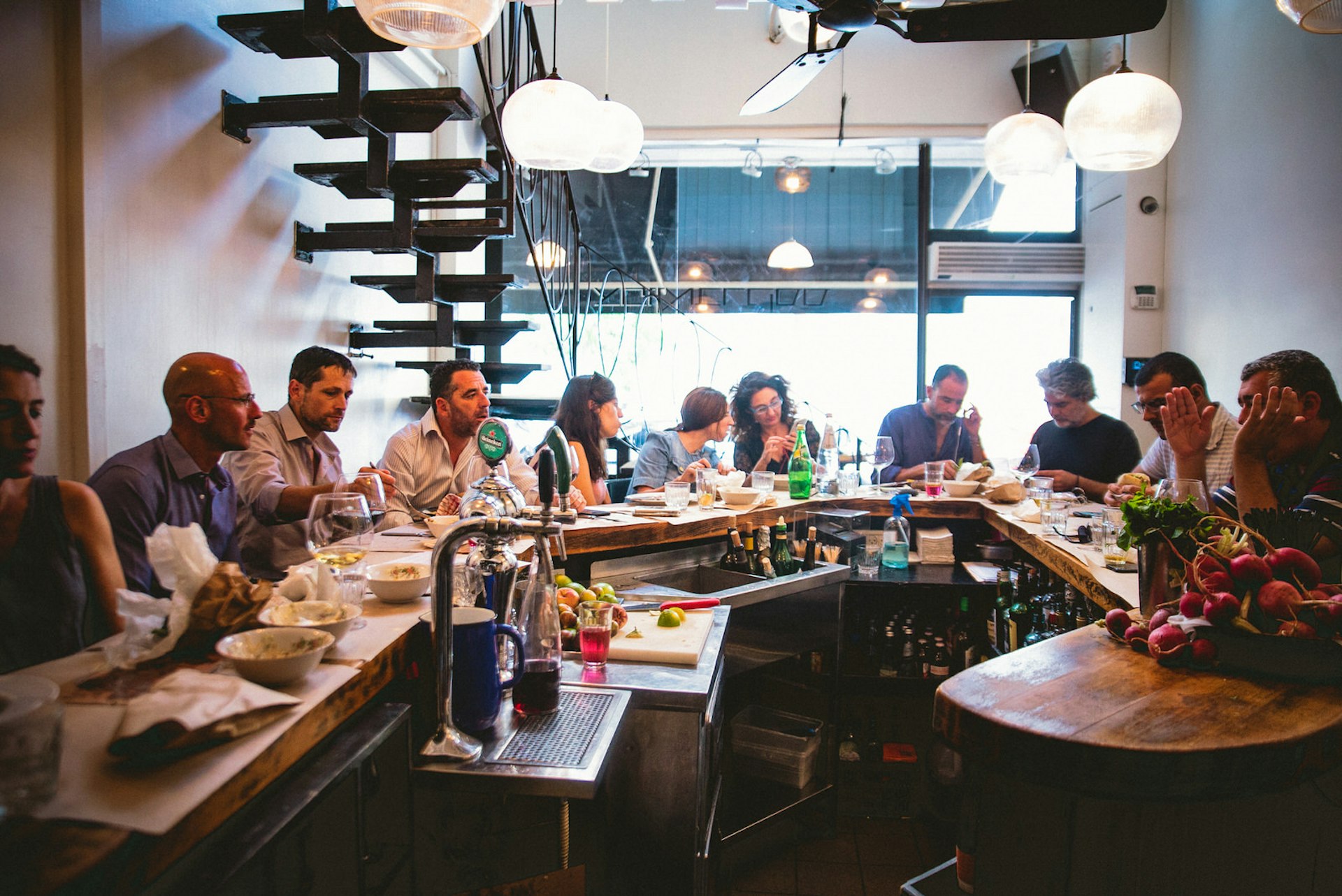 Diners på pallar runt baren i North Abraxas, Tel Aviv