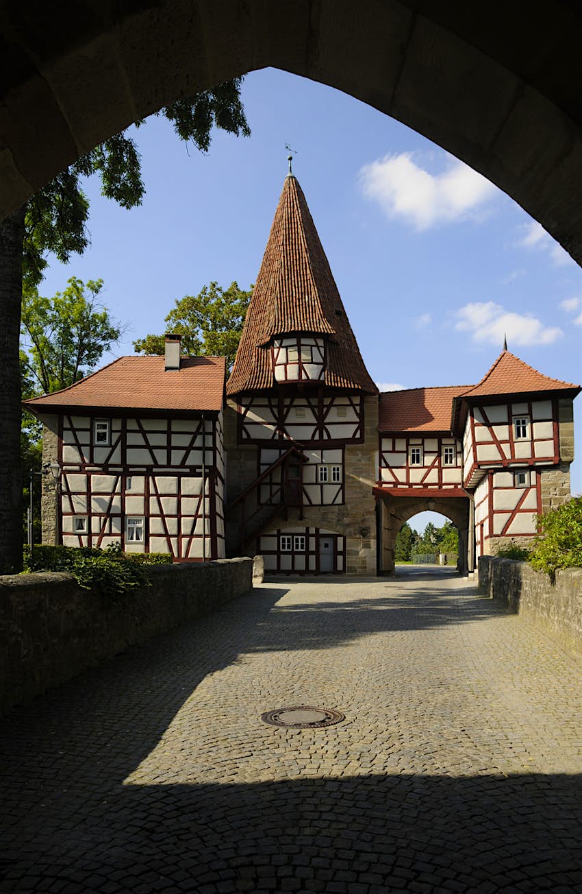 Features - shutterstock_460351486-9871274f9a4e Picture perfect Roedelseer Gate in Iphofen. An archway frames a timbered house and a cobbled street