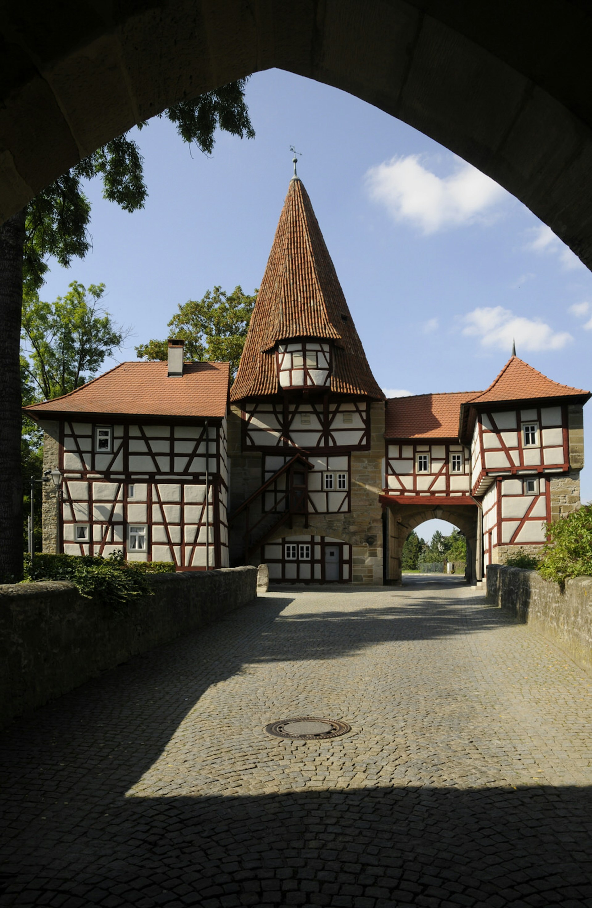 Picture perfect Roedelseer Gate in Iphofen. An archway frames a timbered house and a cobbled street