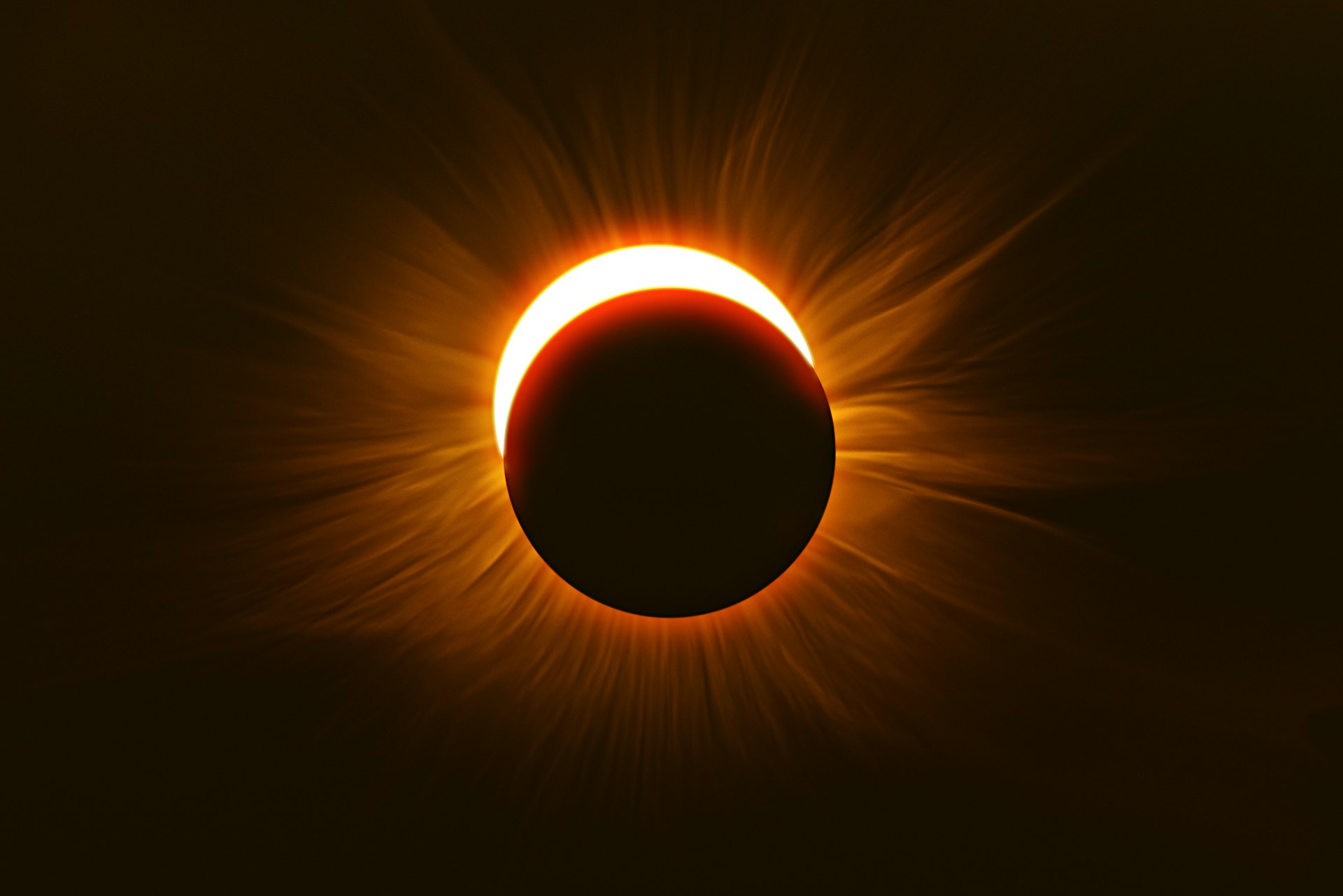 The moon moves across the sun during a solar eclipse; the sun's corona is visible. South America.