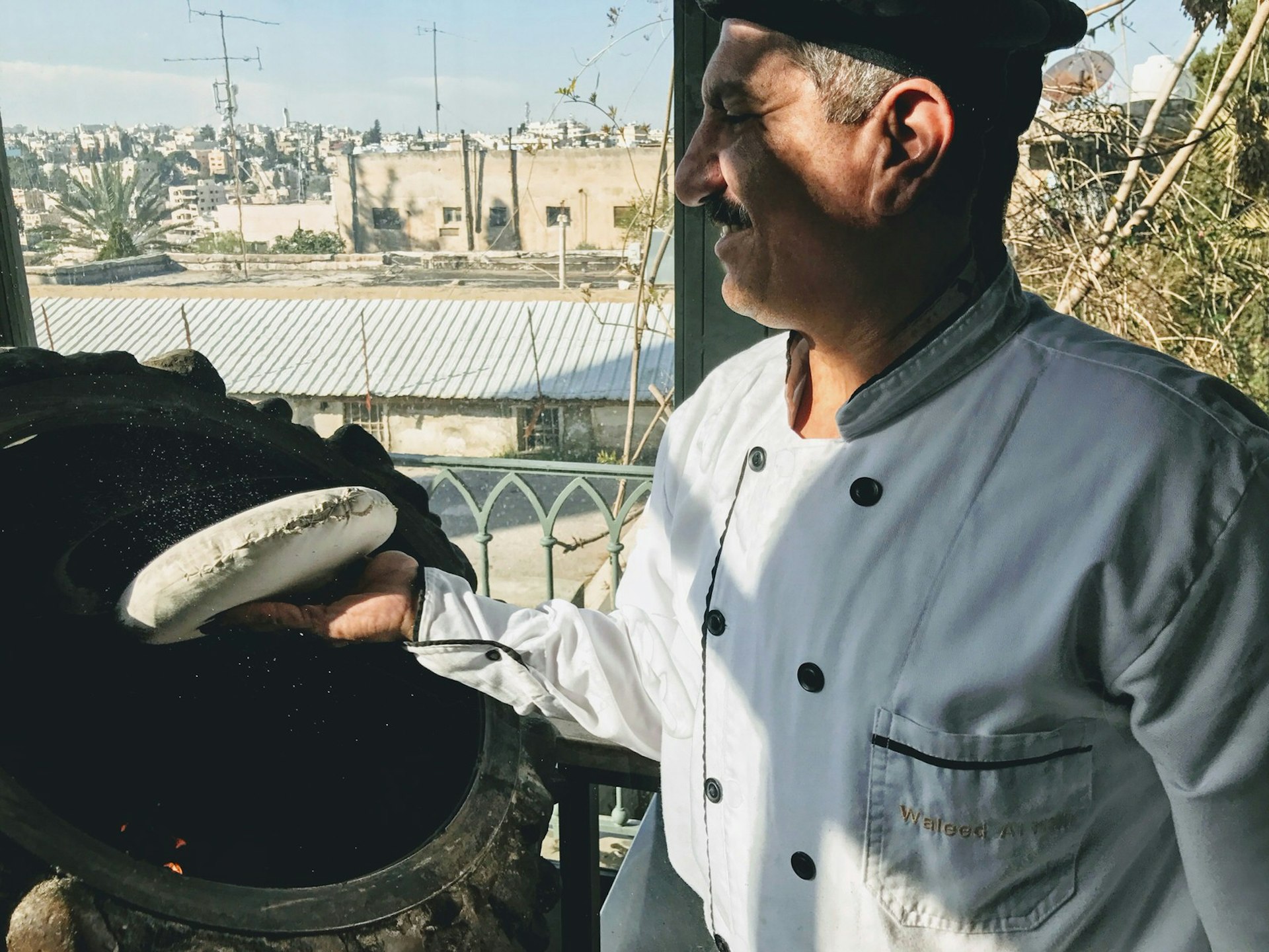 The chefs at Sufra cook fresh bread in the clay oven, Rainbow Street, Amman, Jordan