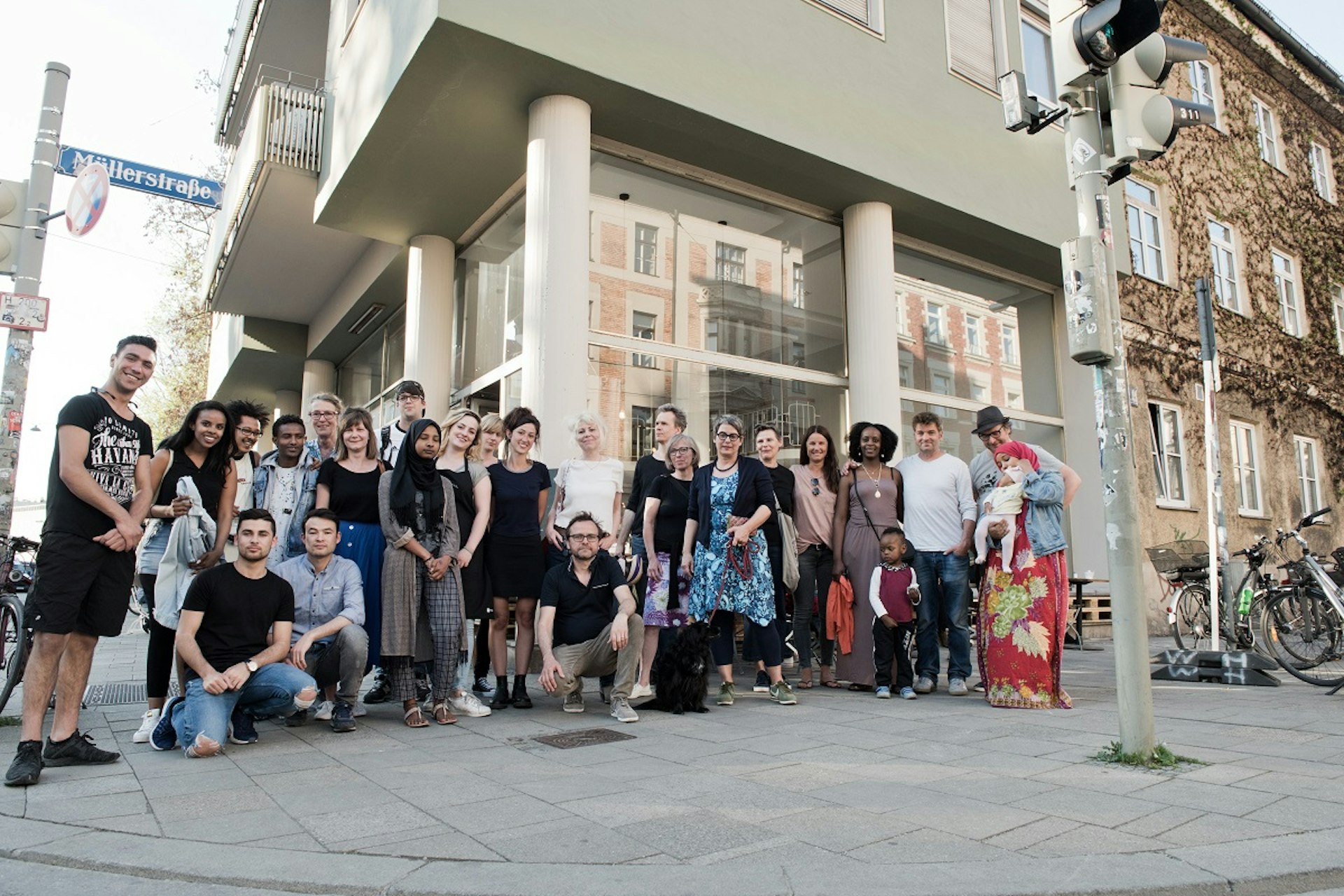 Munich society - Residential inhabitants of the two residential buildings at Müllerstrasse stand with the cafe team from Bellevue di Monaco ©2019 Bellevue di Monaco eG