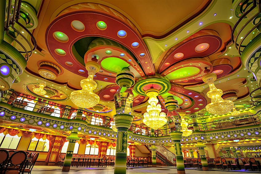 Interior shot of a large room with red, orange, yellow and green neo-Andean architectural designs in El Alto, Boivia