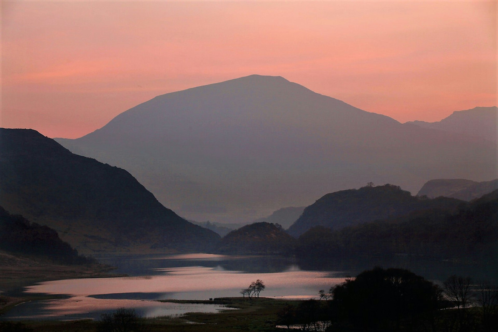 Sunset over Llyn Dinas lake and the surrounding hills © Christopher Furlong / Getty Images