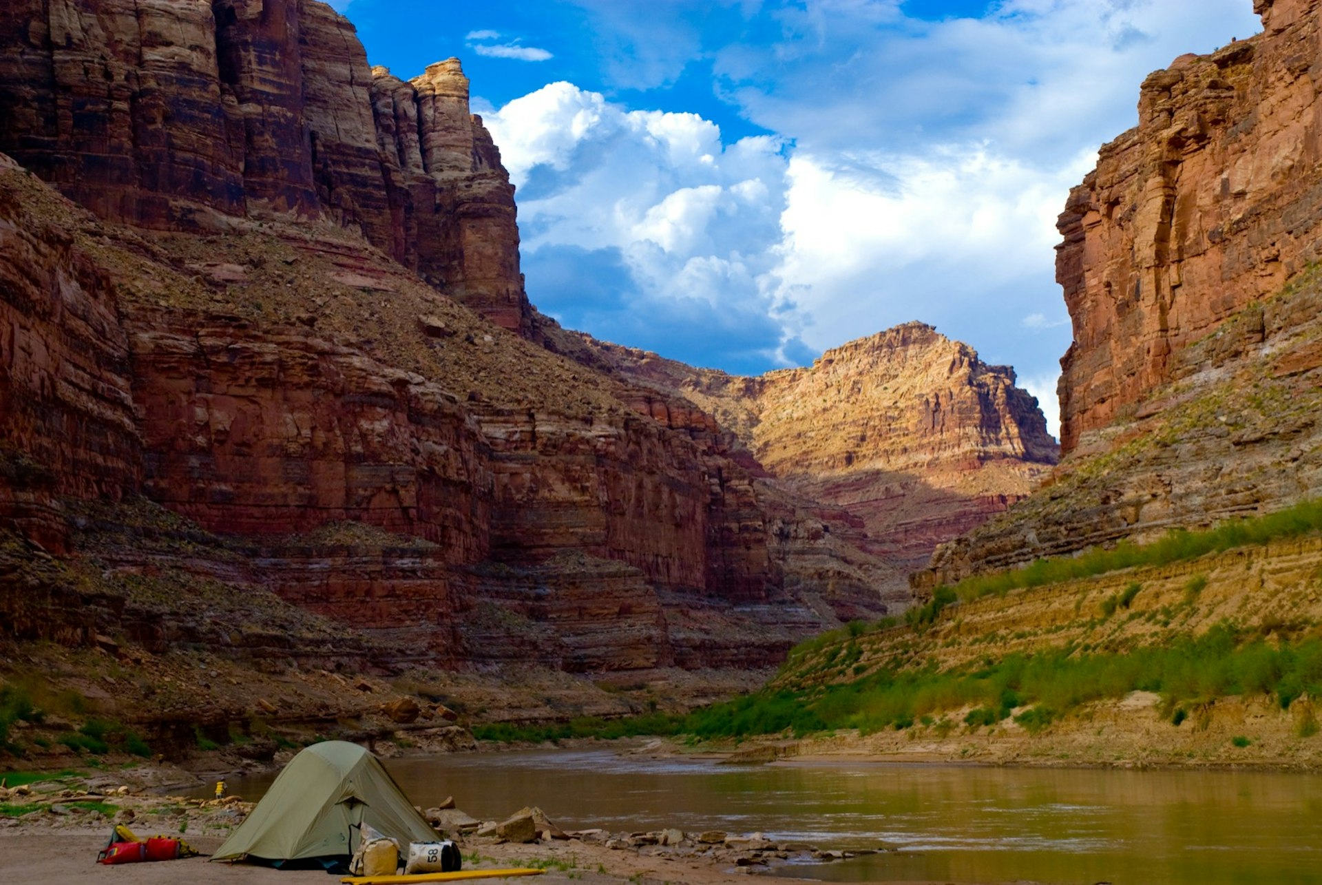 Campsite with tent and gear in Cataract Canyon on the Colorado River in Utah.