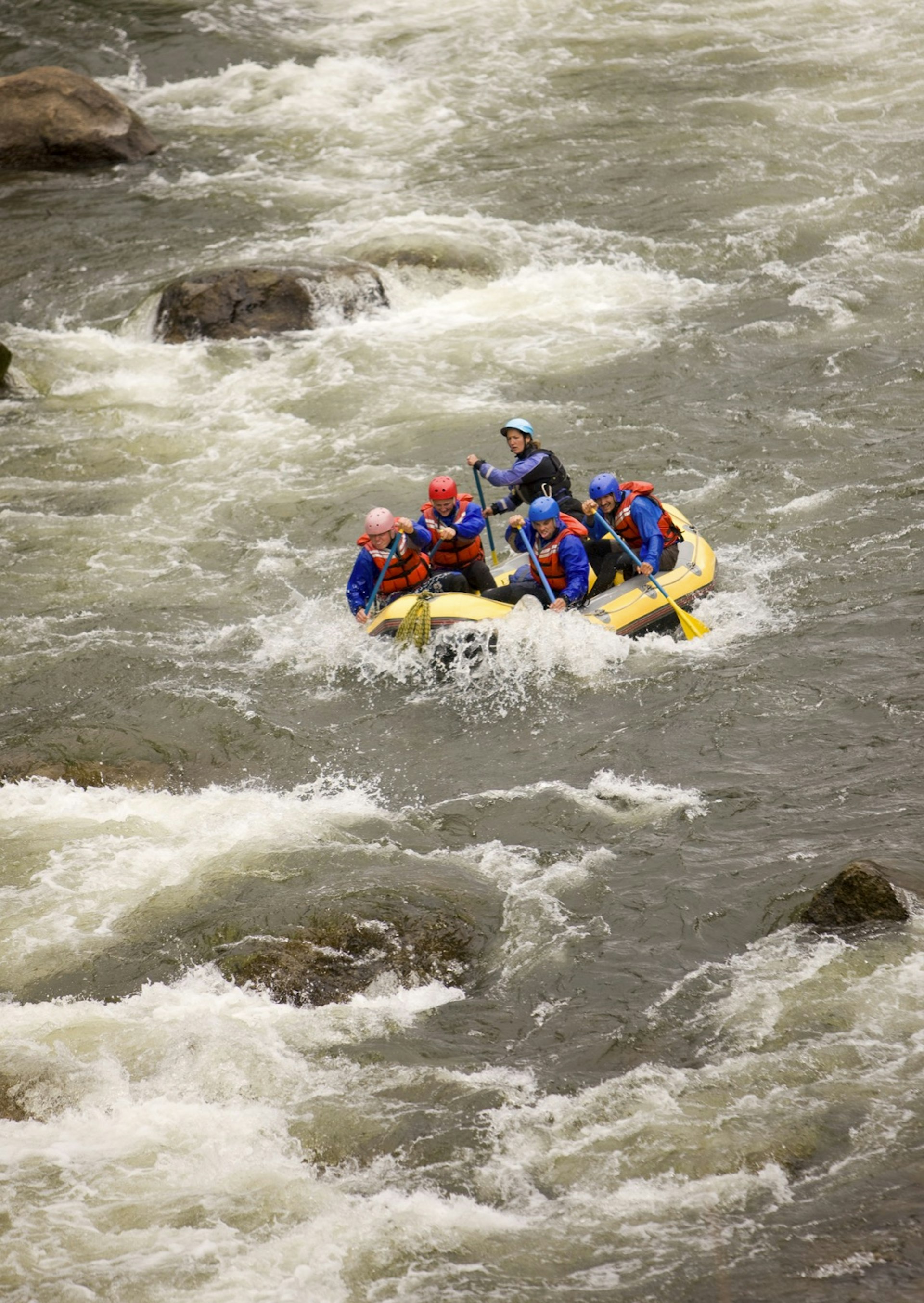 Four people and a guide raft down the Arkansas River in Colorado.