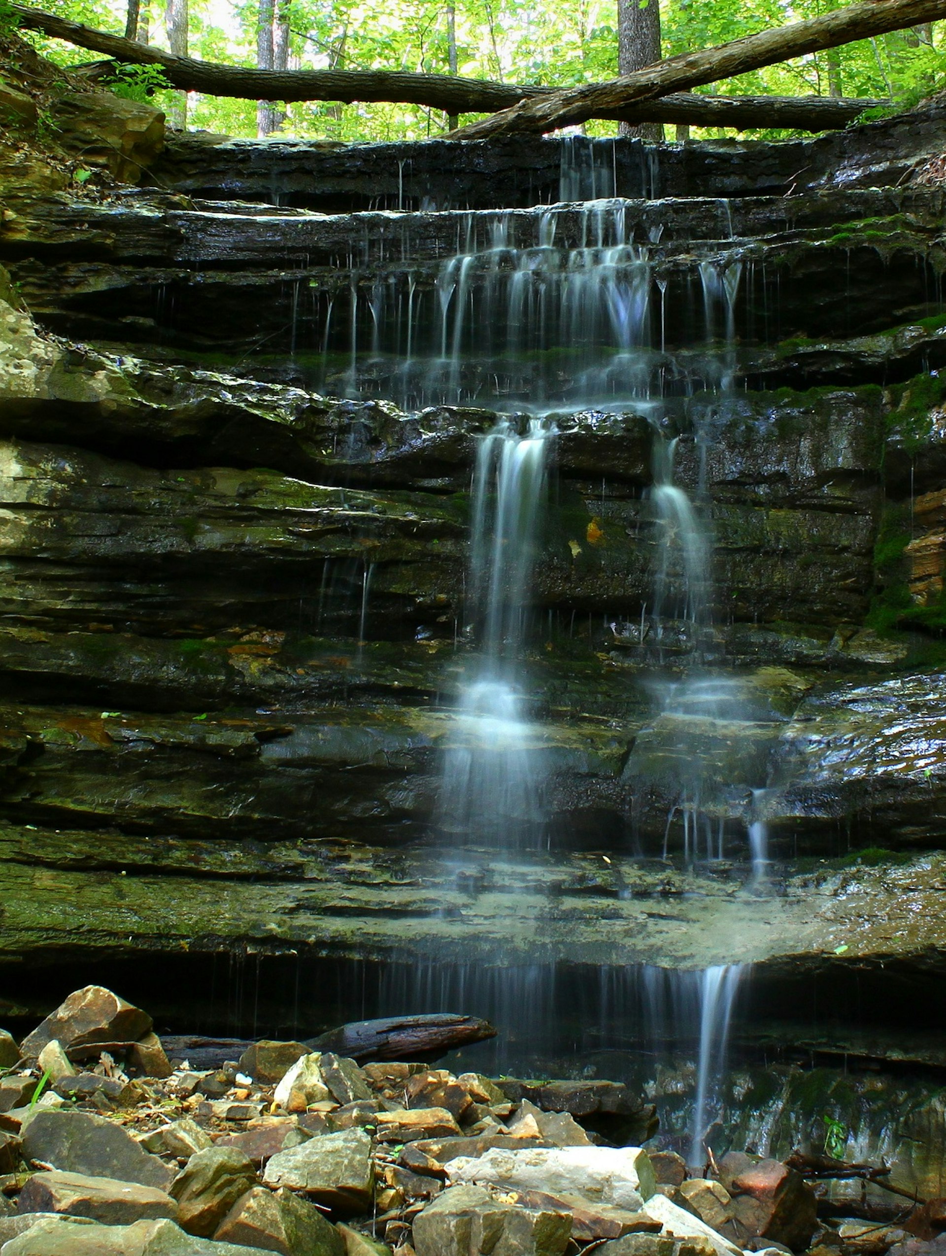 Trickling waterfall runs over limestone rocks.