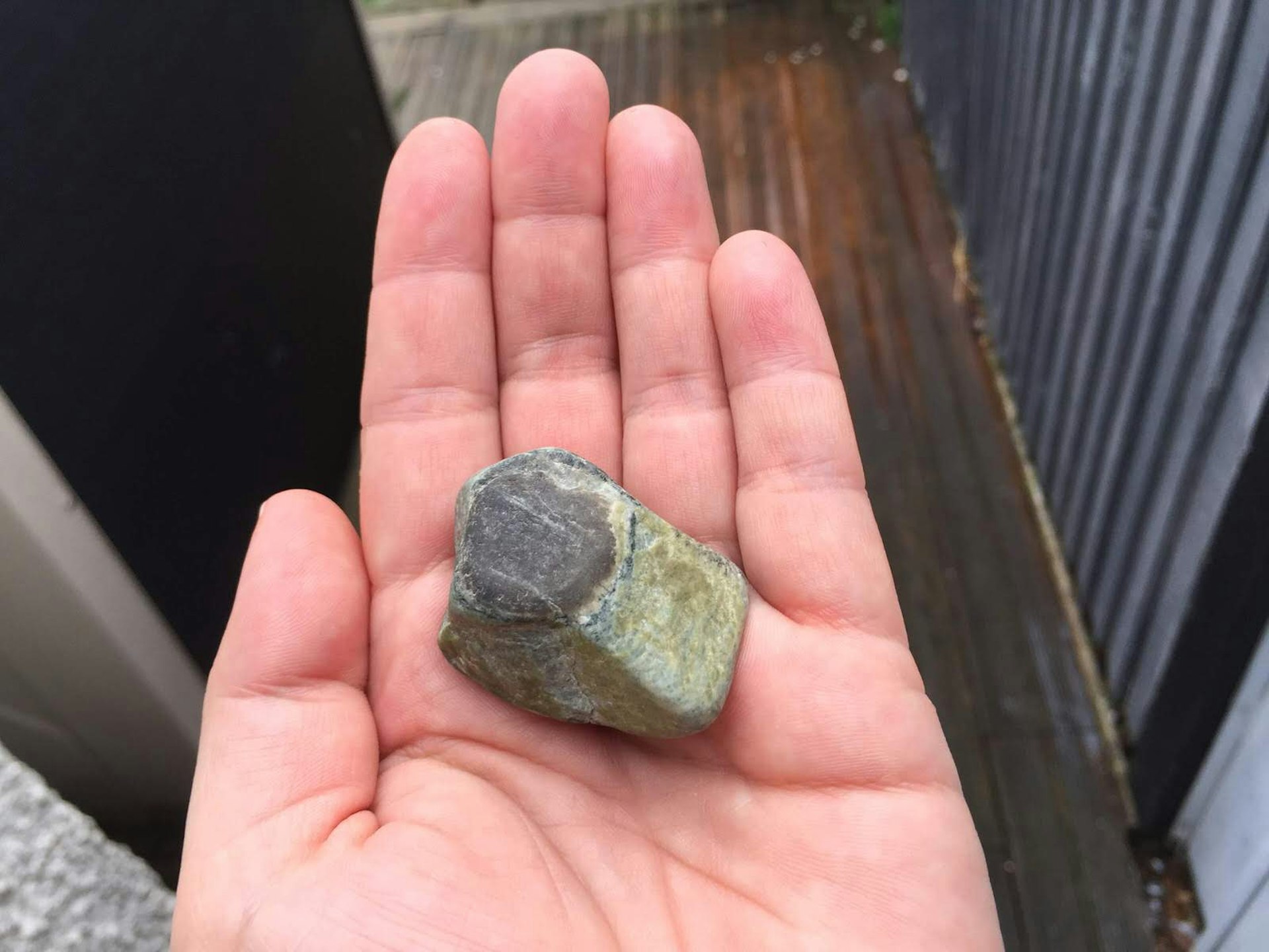 A small stone held in the palm of a hand