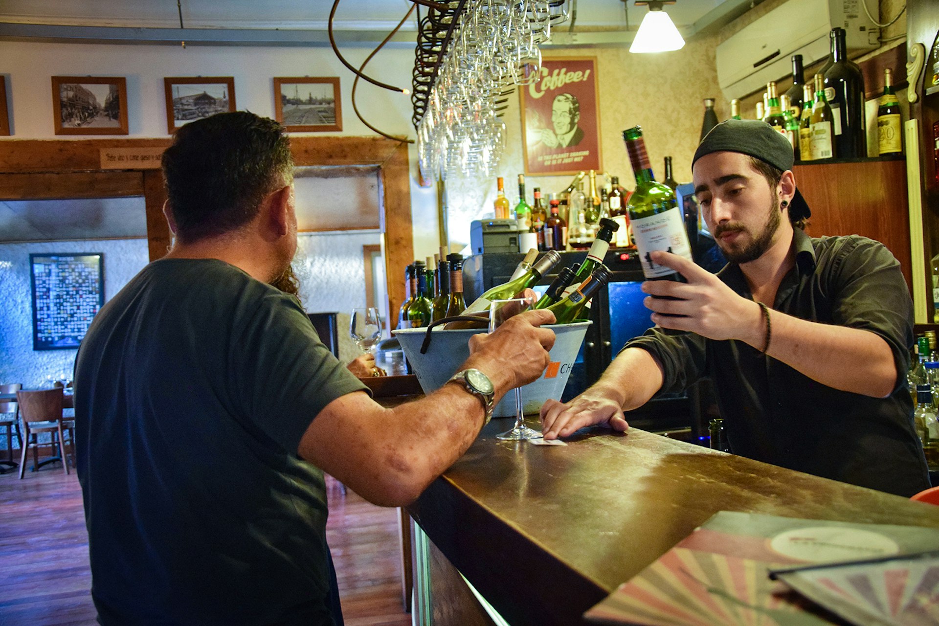 A bartender pours a glass of wine for a patron at a wine bar in Santiago, Chile