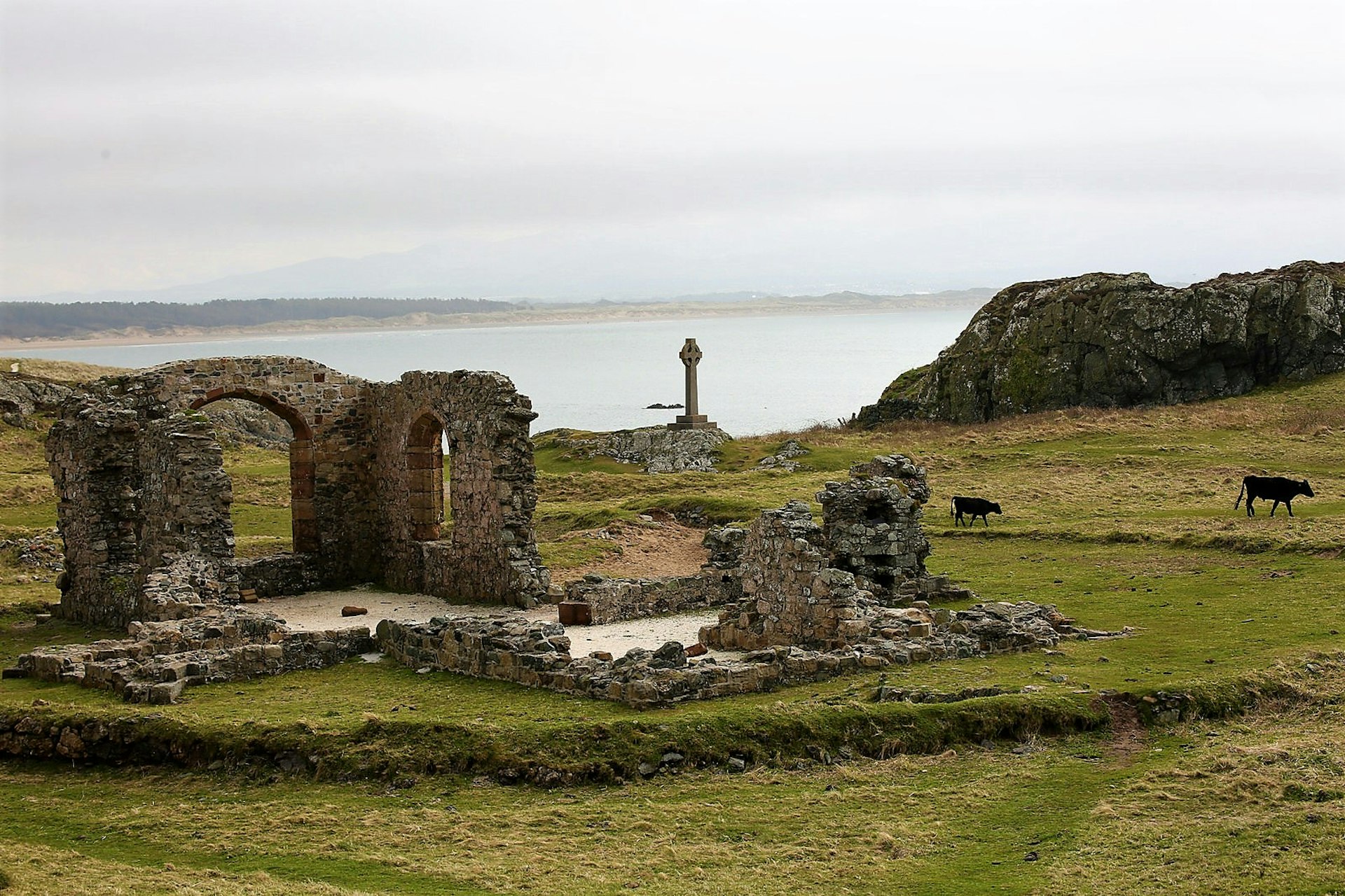 The ruined church of St Dwynwen with the sea in the background © Crown copyright (2018) Visit Wales. All rights reserved