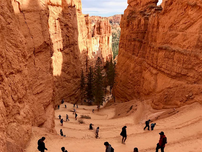 Features - Queens-Garden-3de0dbb5d056 People walk back and forth along a switchback trail between two sheer rock walls