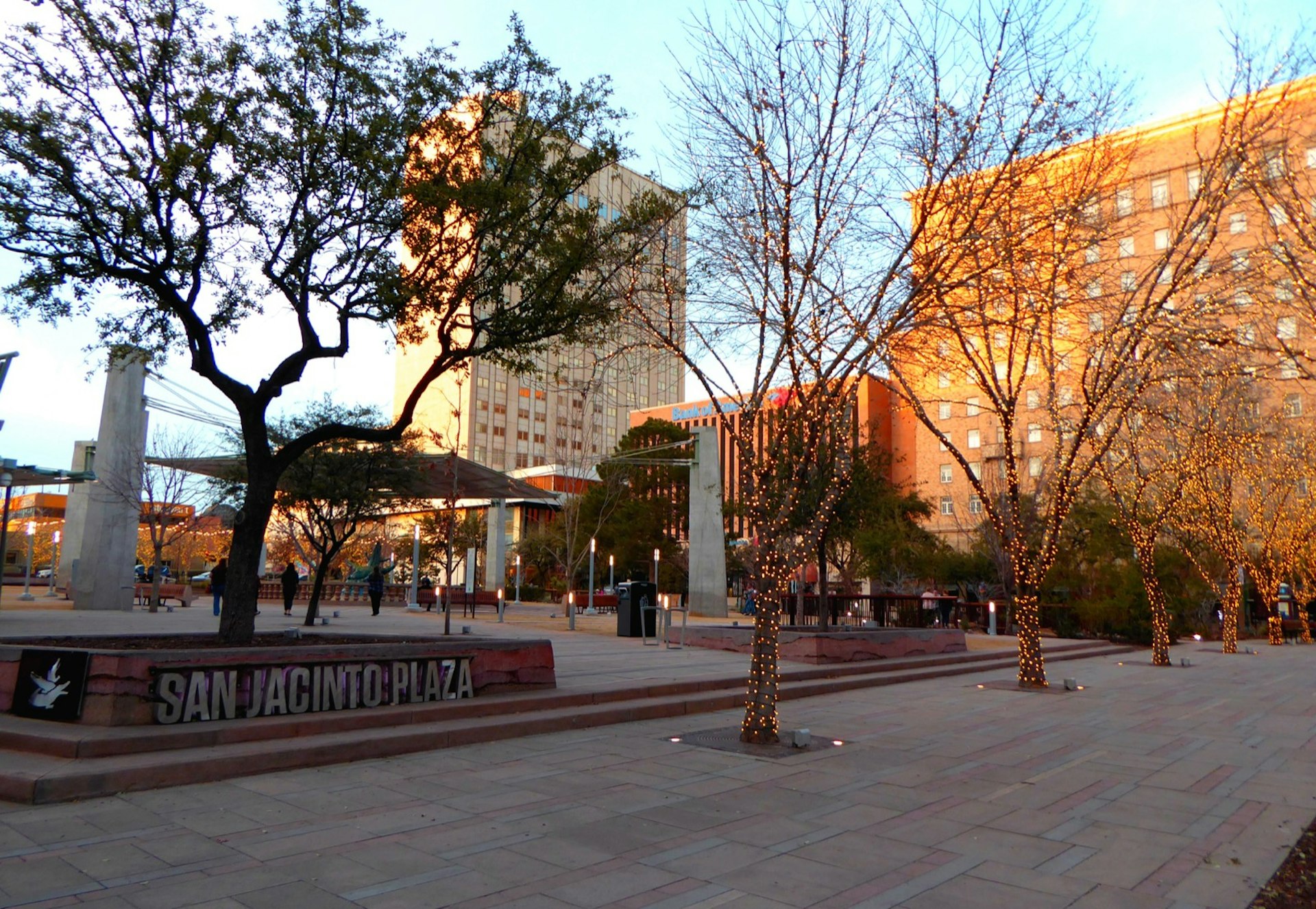 A stone-floored plaza is interspersed with trees and buildings in El Paso Texas
