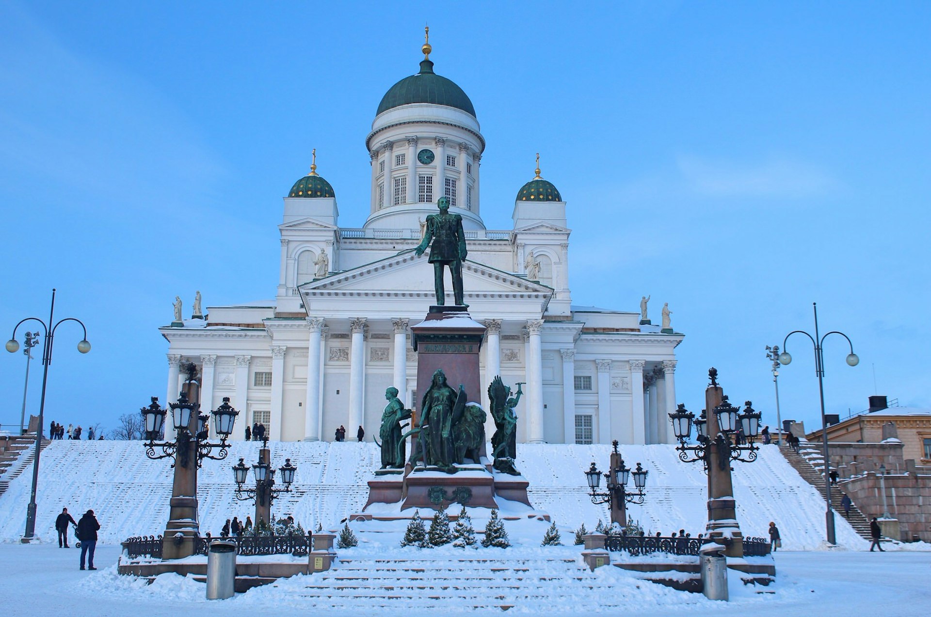 Snowy, twilight shot of Tuomiokirkko, Helsinki, with the statue of Tsar Alexander in the middle ground
