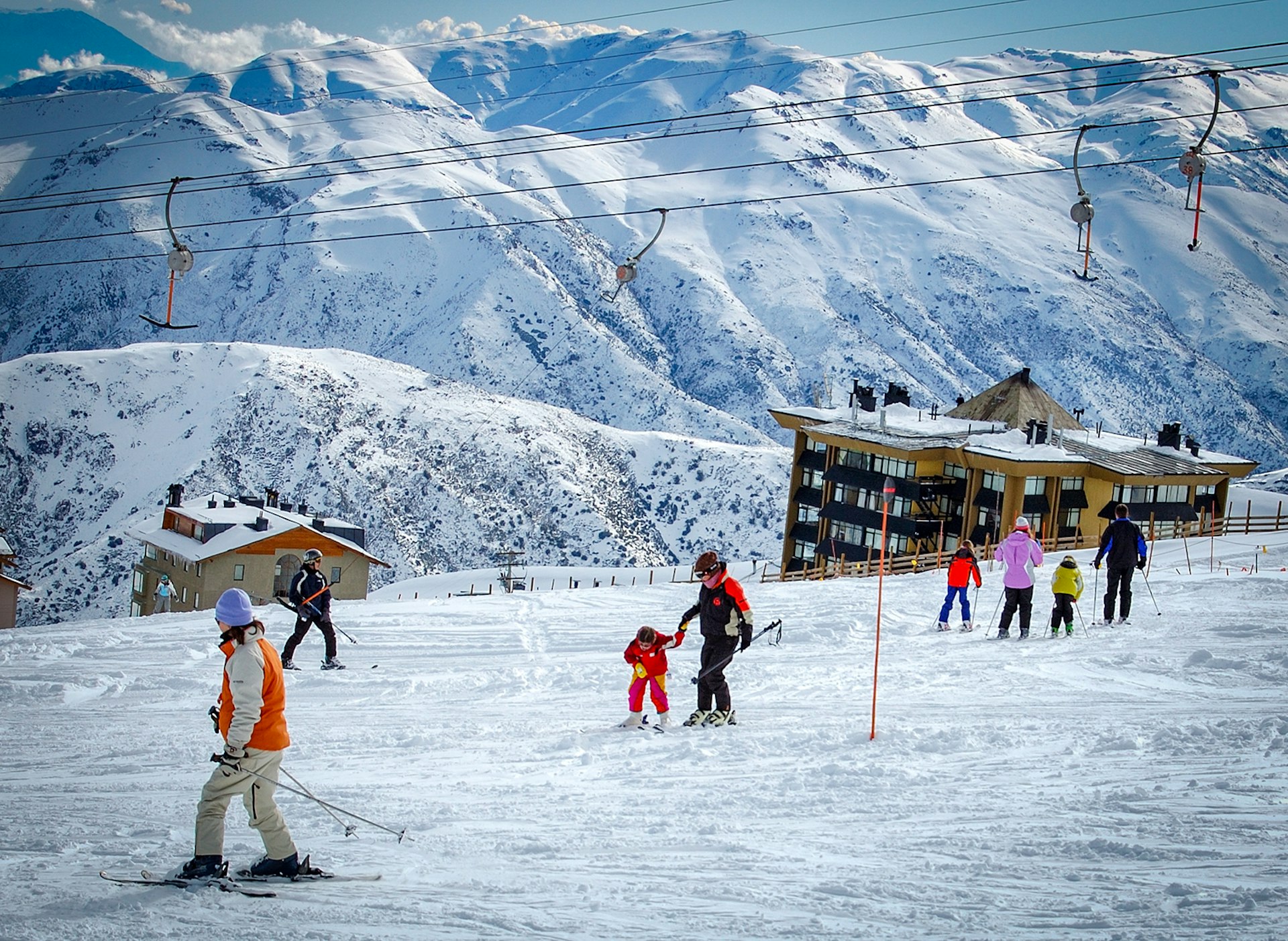 Multiple families make their way across the snow at a ski resort in Tres Valles, Chile