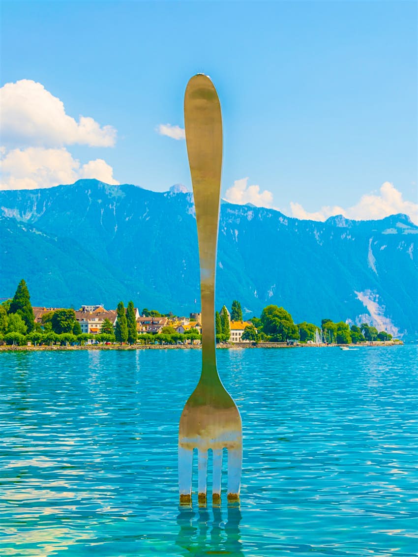 A giant fork statue rising from Lake Geneva at foodie-focused Vevey