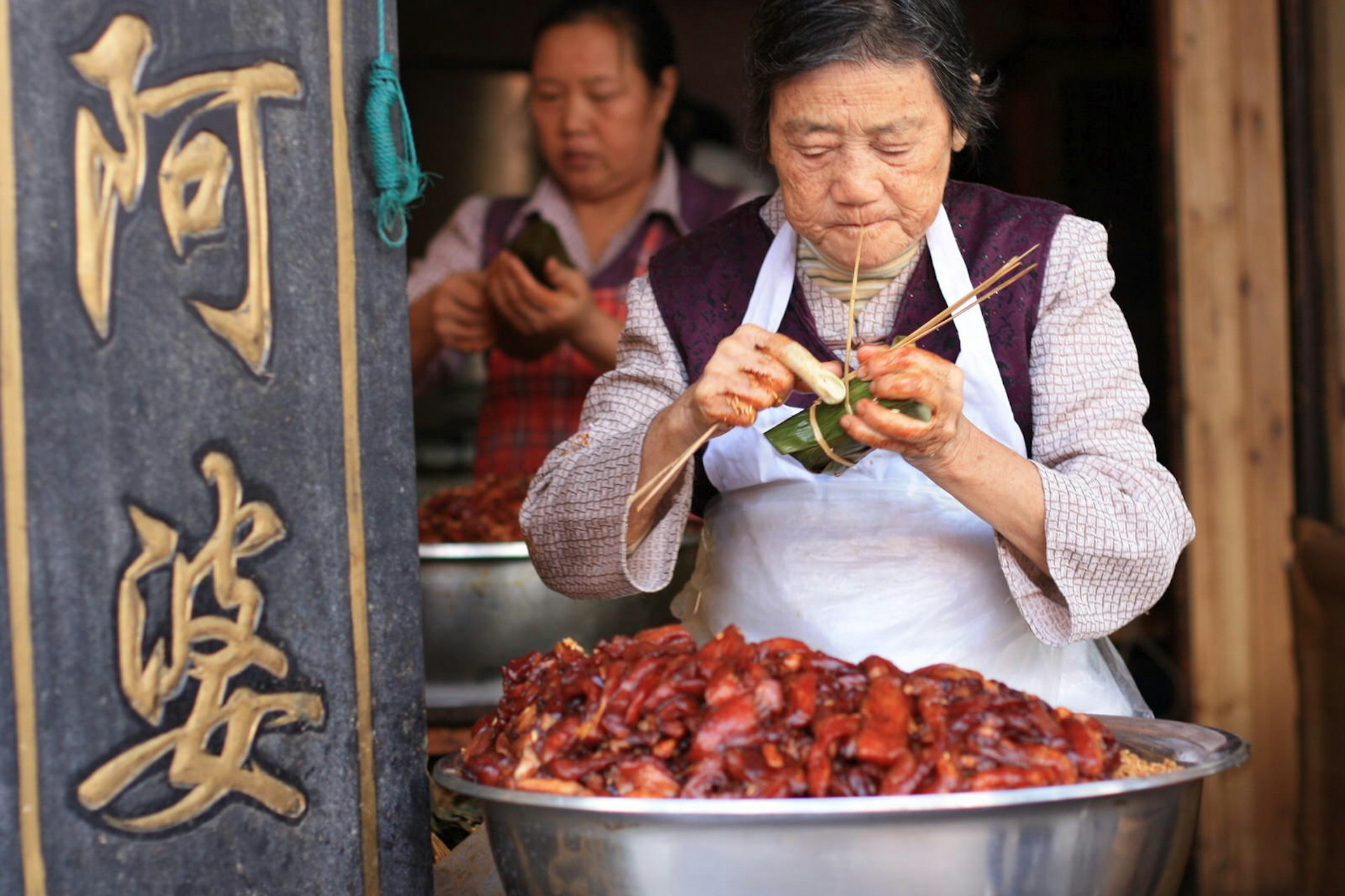 Ladies preparing bamboo-wrapped meat in Zhujiajiao