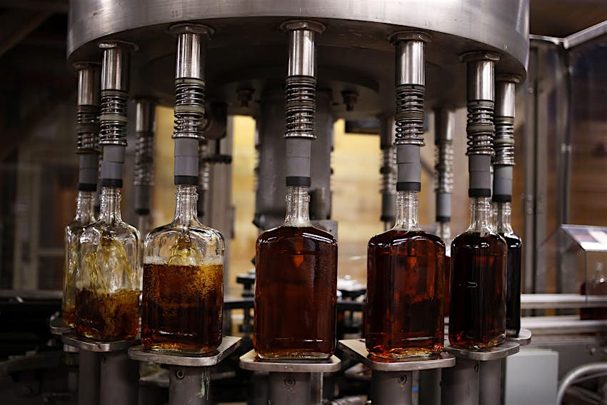 Features - Bottles of single barrel bourbon are filled on the bottling line at a distillery Features - Bottles of single barrel bourbon are filled on the bottling line at a distillery
