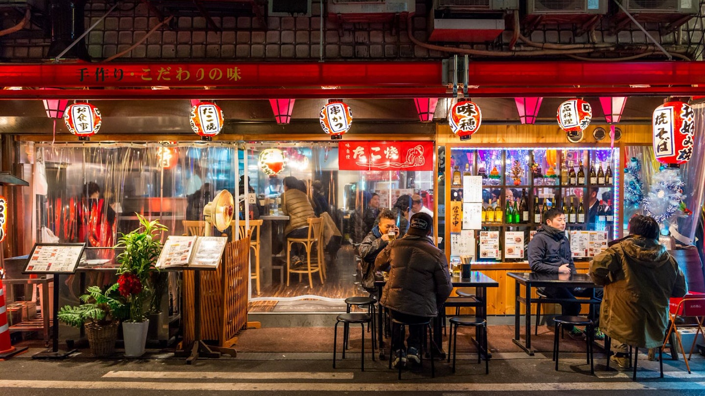 Locals gather at a restaurant in Osaka after dark