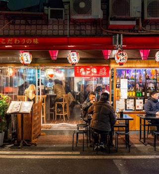 Locals gather at a restaurant in Osaka after dark