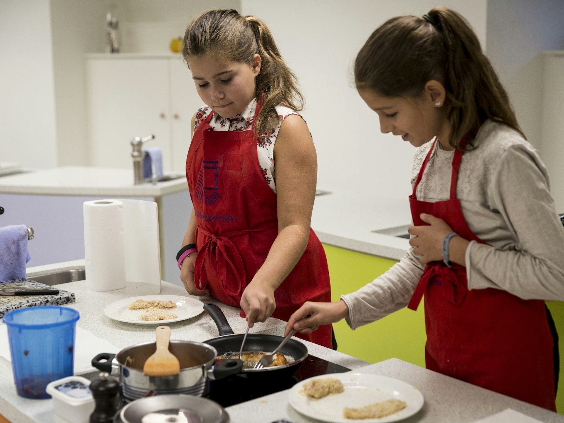 Two girls doing a cooking workshop at Alimentation