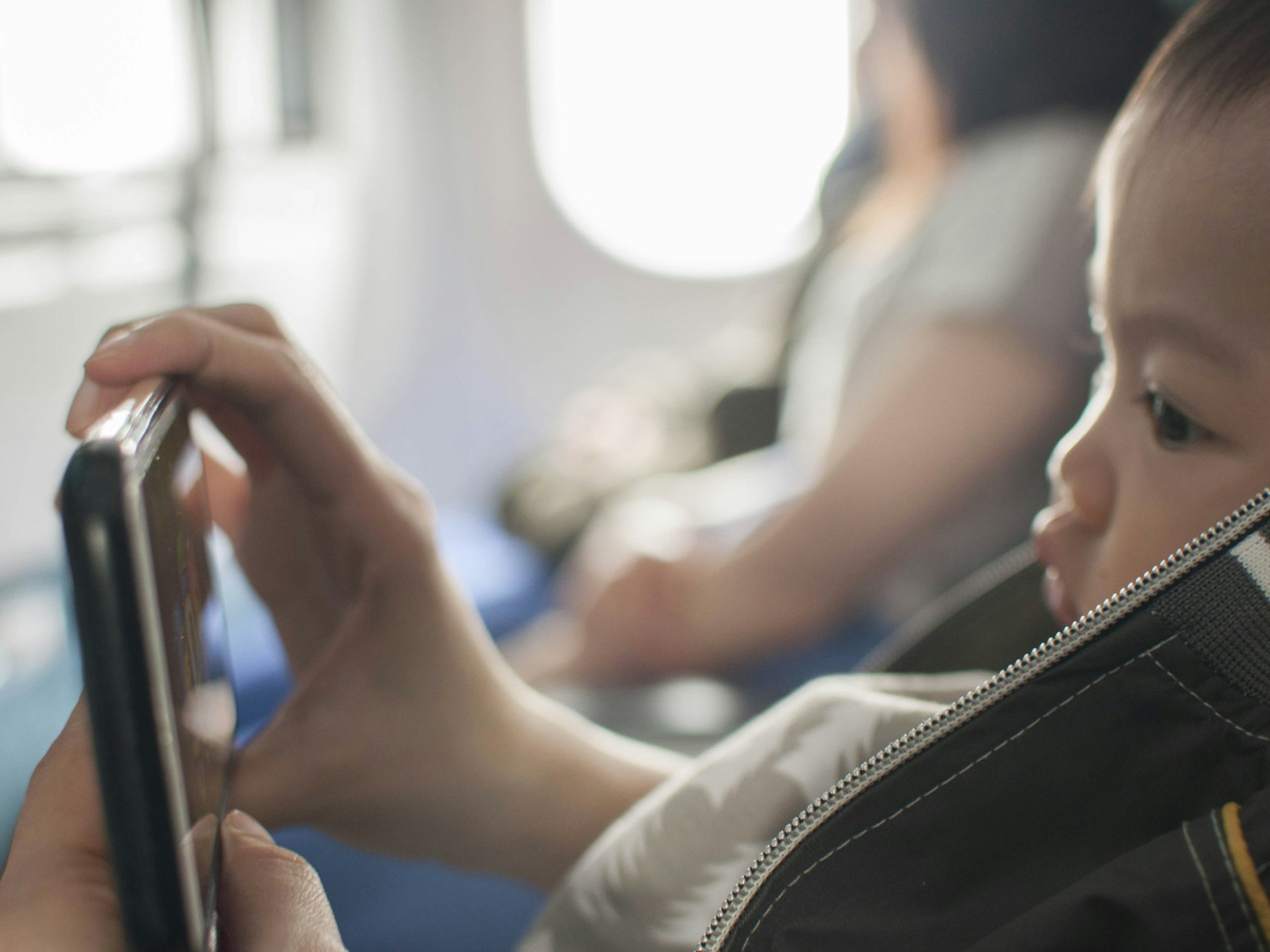 Child watching videos on a phone on a plane