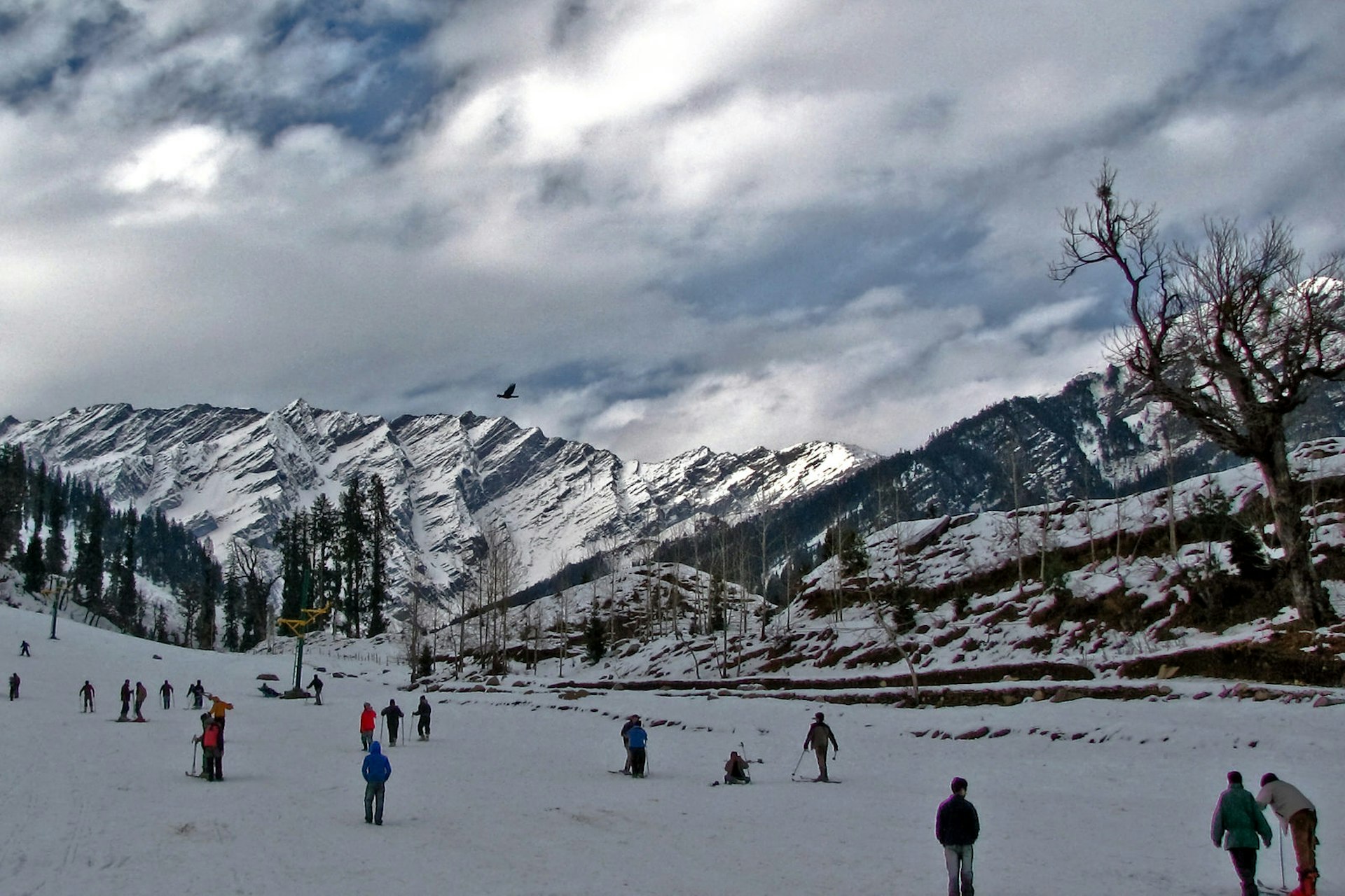 A group of skiers at the bottom of a snow-covered valley in Himachal Pradesh